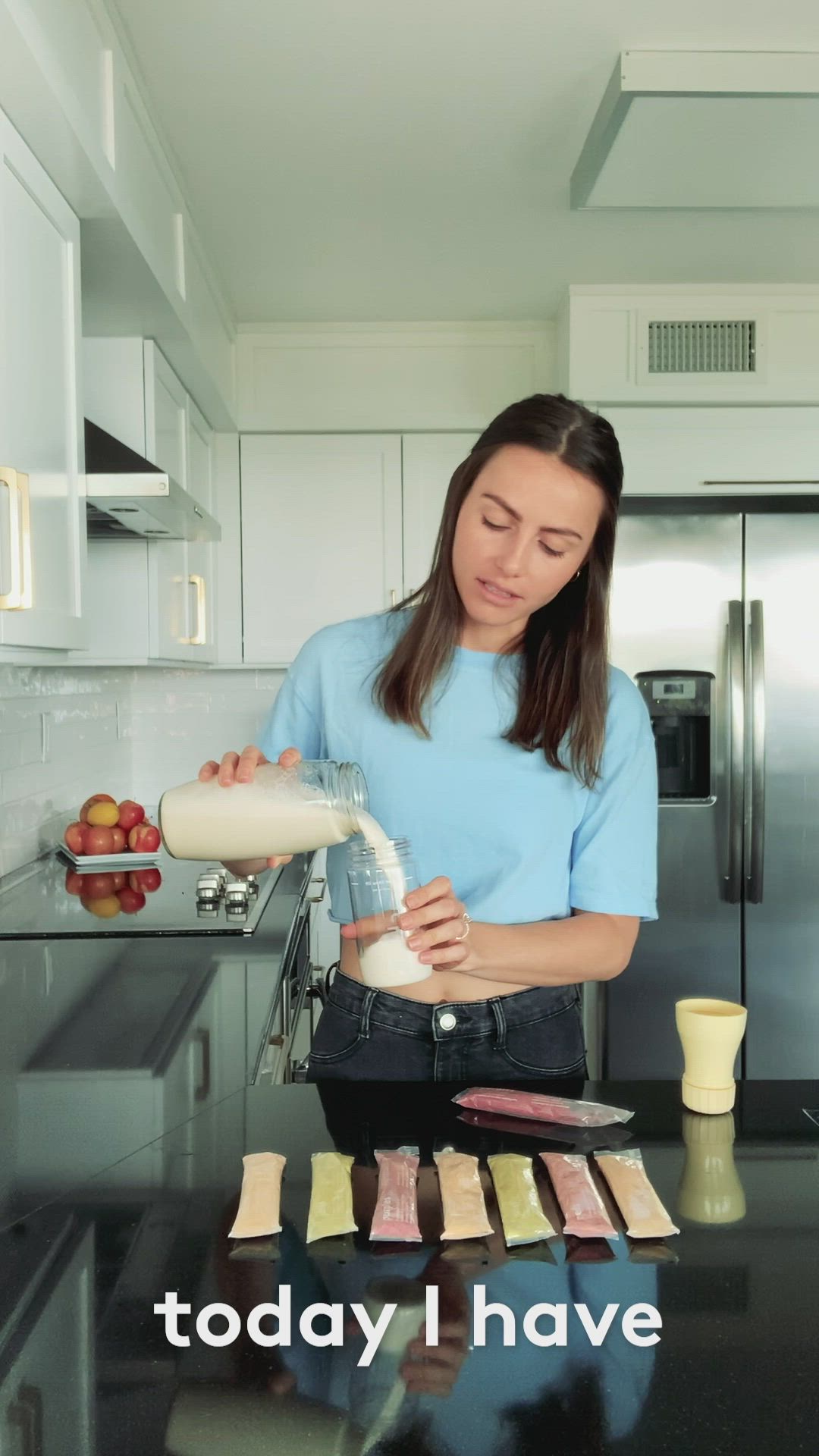 This may contain: a woman is pouring something into a blender