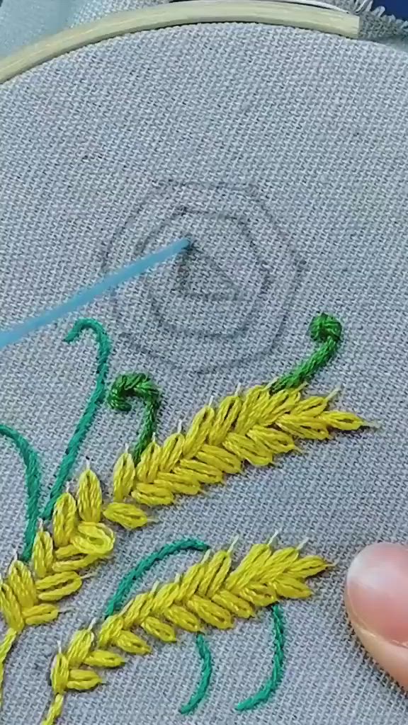 This may contain: someone is stitching something on a piece of fabric with yellow and green thread in the middle