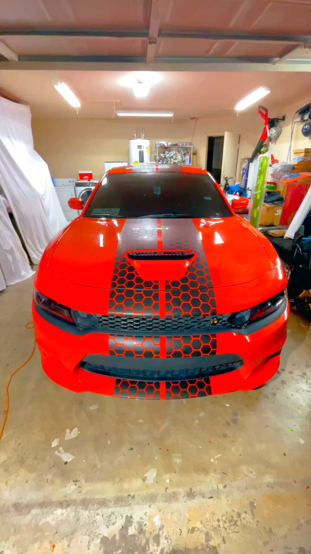 This may contain: an orange sports car parked in a garage