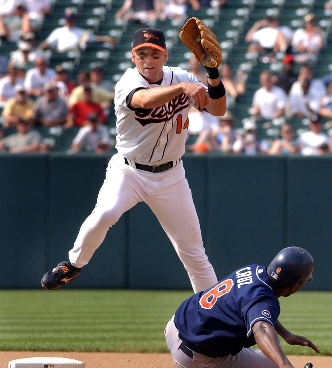 BALTIMORE -- 6/12/02 -- Baltimore Orioles vs. San Diego Padres at Camden Yards: Mike Bordick completes a double play over Deivi Cruz after replacing Melvin Mora as short stop in the seventh inning. Mora was thrown out of the game for tossing his bat in the sixth inning. staff/Elizabeth Malby