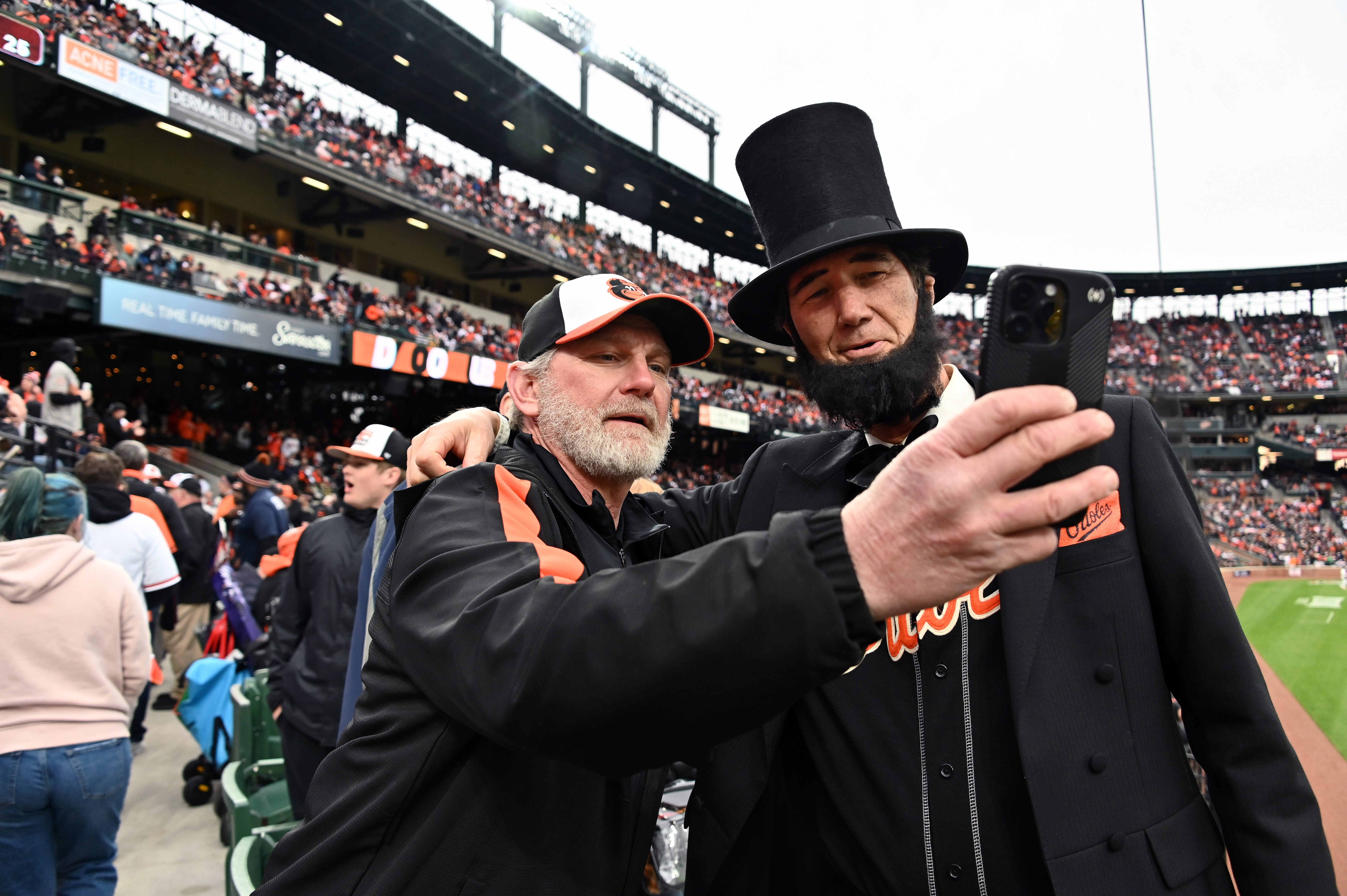 Mar. 28, 2024: Ray Price, of Kennedyville, takes a selfie with Abe Lincoln presenter Duke Thompson, of Havre de Grace, on opening day. The Baltimore Orioles host the Los Angeles Angels at Oriole Park at Camden Yards. (Kim Hairston/Staff)