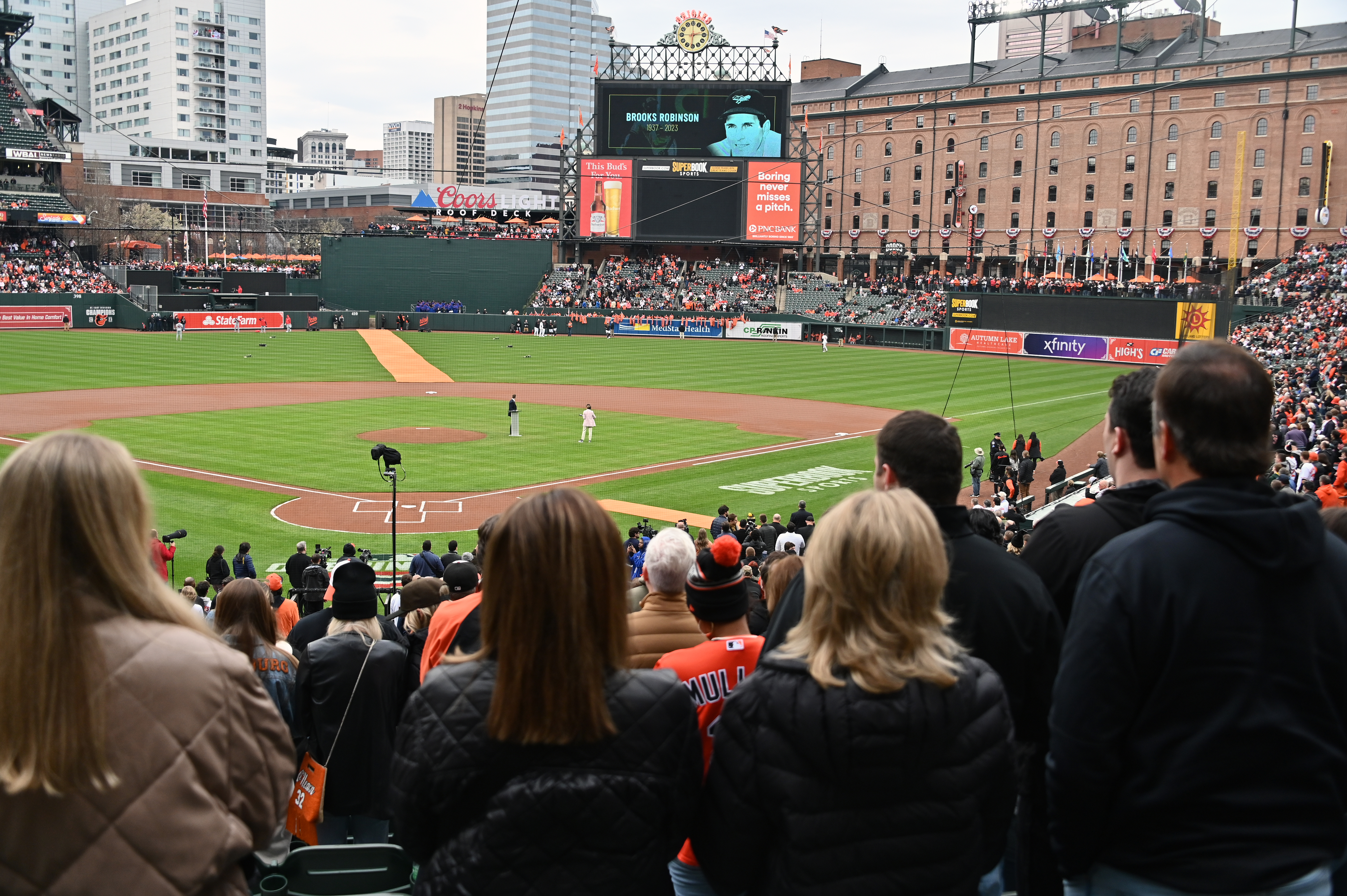 Mar. 28, 2024: An image of Brooks Robinson is on the scoreboard as the Baltimore Orioles pay tribute to those they have lost before an opening day game against the Los Angeles Angels at Oriole Park at Camden Yards. (Kim Hairston/Staff)