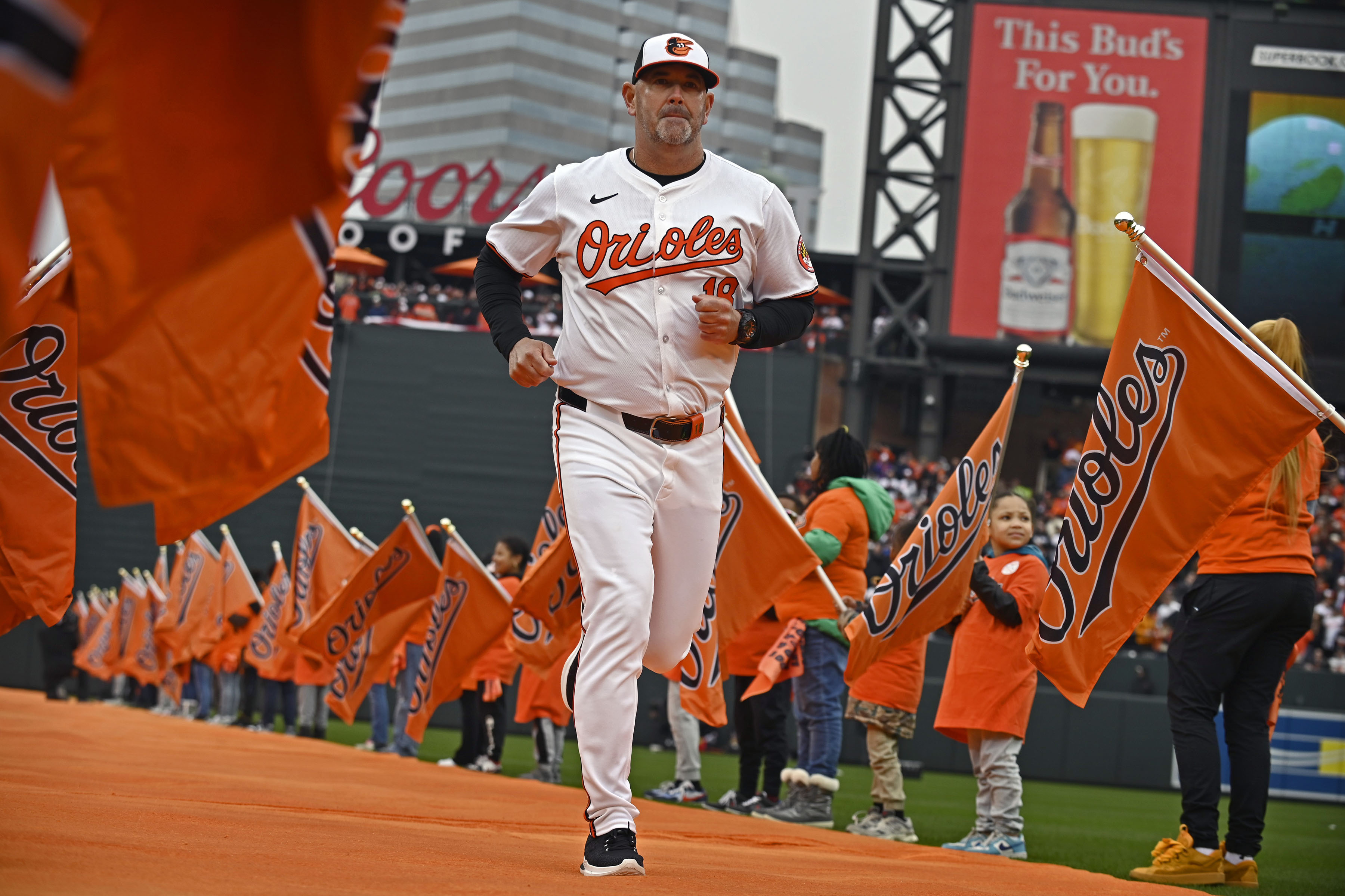 Mar 28, 2024: Orioles manager Brandon Hyde runs out on the orange carpet during 2024 season opening day ceremony at Oriole Park at Camden Yards. (Kenneth K. Lam/Staff)