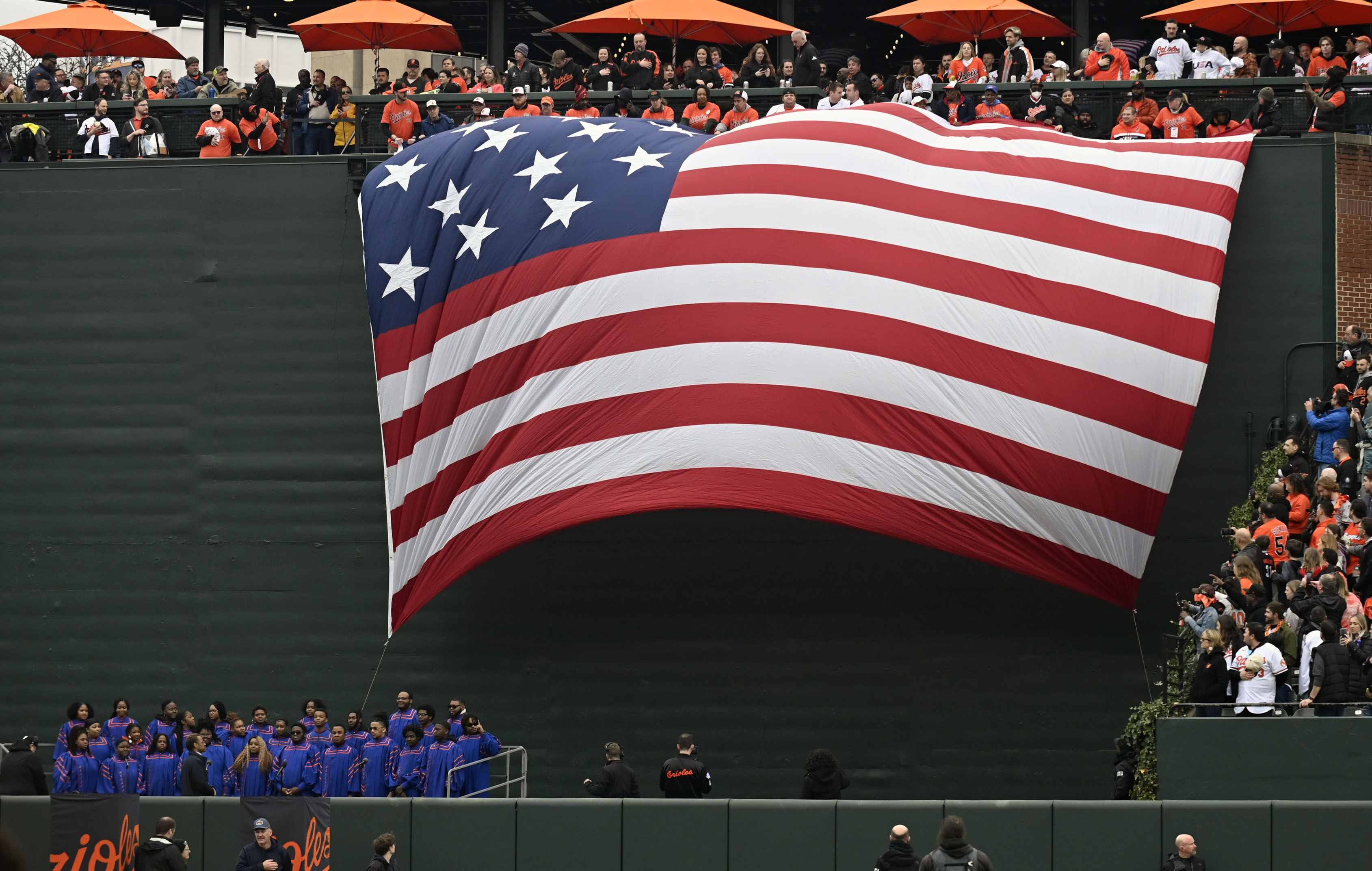 Mar 28, 2024: The 30'x42' Stars from Fort McHenry is lowered from the batter's eye before the singing of the National Anthem by the Moran Sate University Choir on opening day at Oriole Park at Camden Yards. (Kenneth K. Lam/Staff)