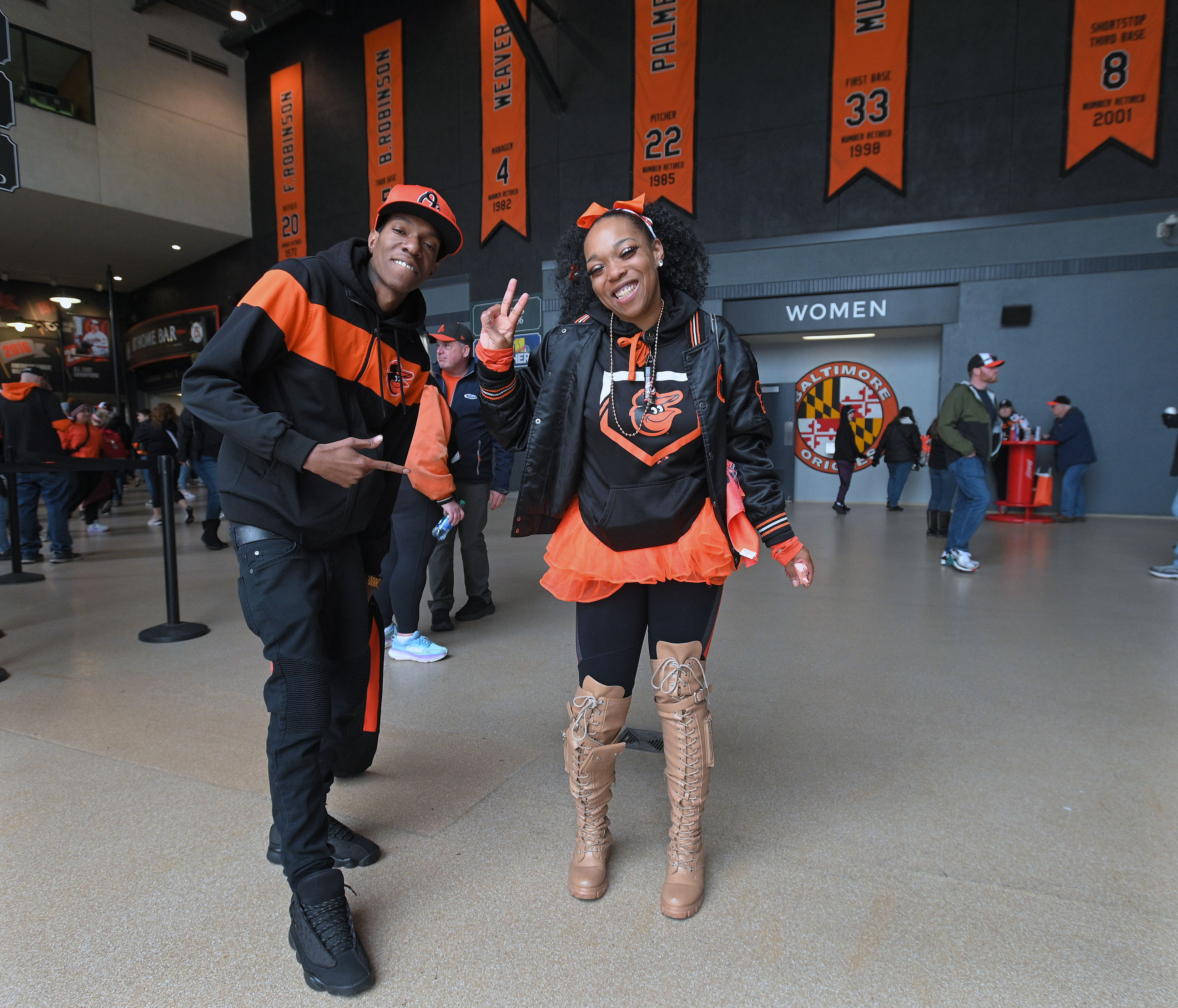 Mar 28, 2024: Jazmine Gibbs, right, of Baltimore, and partner Tariq Caple, are dressed in their O's gears for their 10th opening day Orioles' 2024 season opener at Oriole Park at Camden Yards. (Kenneth K. Lam/Staff)