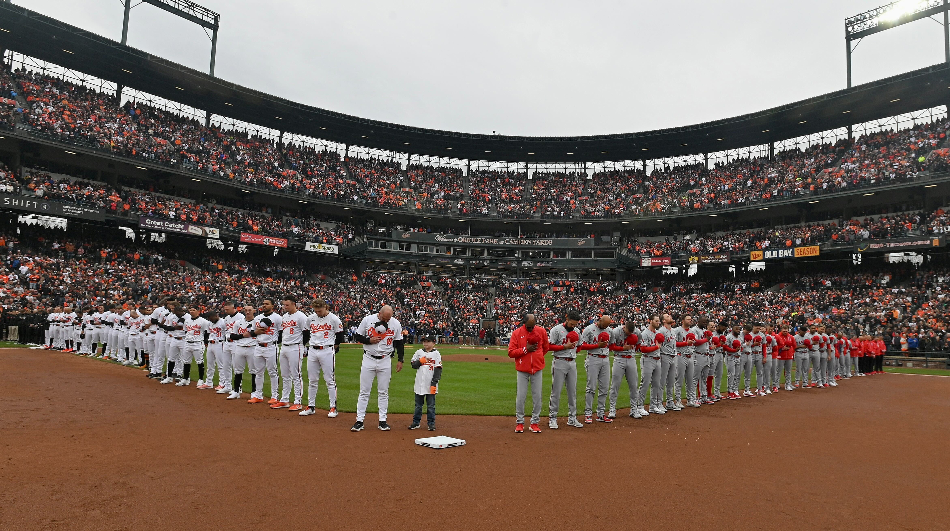 March 28, 2024: Players take a moment of silence in memory of Francis Scott Key Bridge victims during opening day ceremonies at Oriole Park at Camden Yards. (Kenneth K. Lam/Staff)