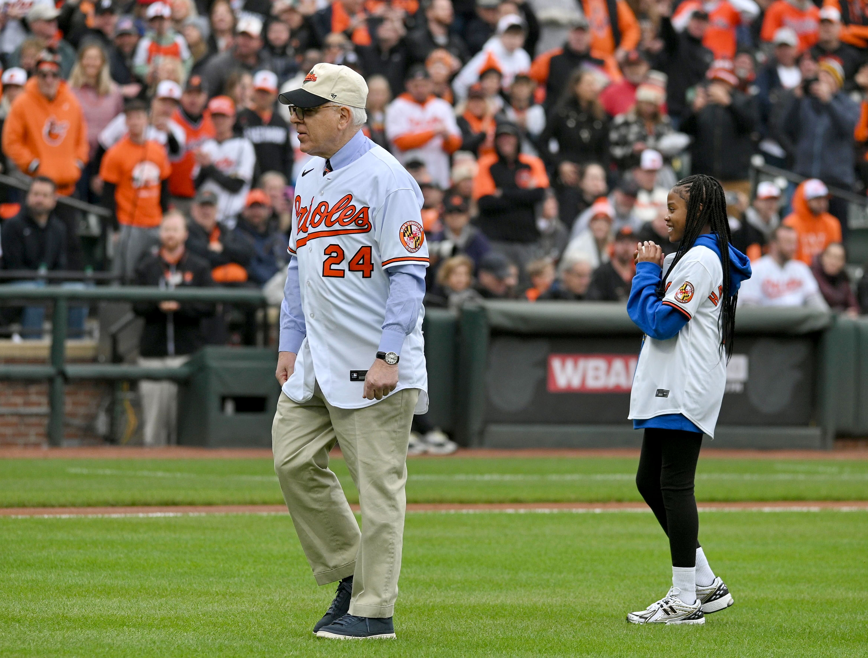 March 28, 2024: Orioles' new owner David Rubenstein gives some instruction to Aubree Singletary, 10 of Baltimore as she gets ready to throw out the ceremonial first pitch on opening day at Camden Yards. ( Kenneth K. Lam/Staff)
