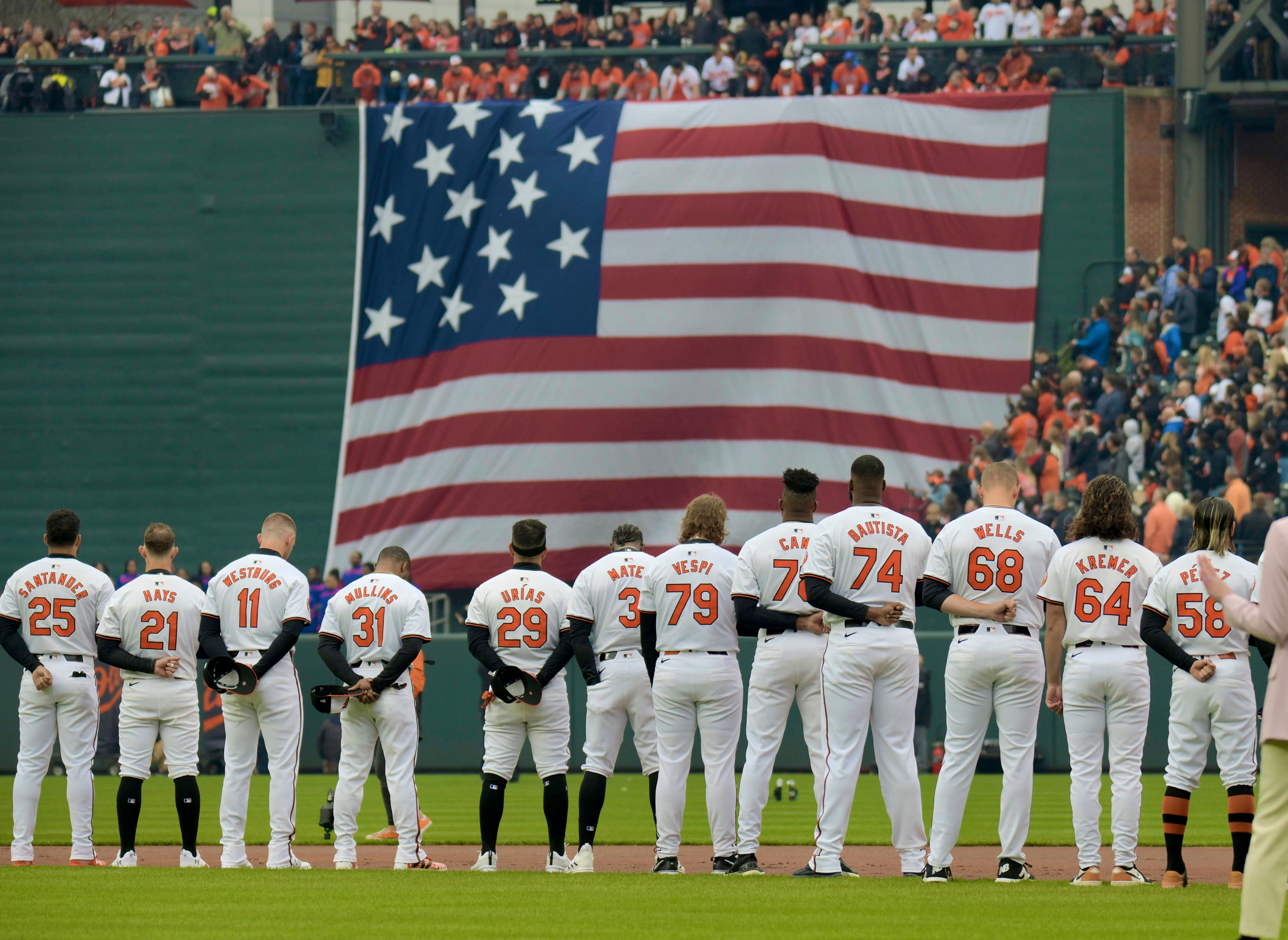 March 28, 2024: The Baltimore Orioles players line up on the field for the National Anthem during opening day ceremonies at Oriole Park at Camden Yards. (Karl Merton Ferron/Staff)