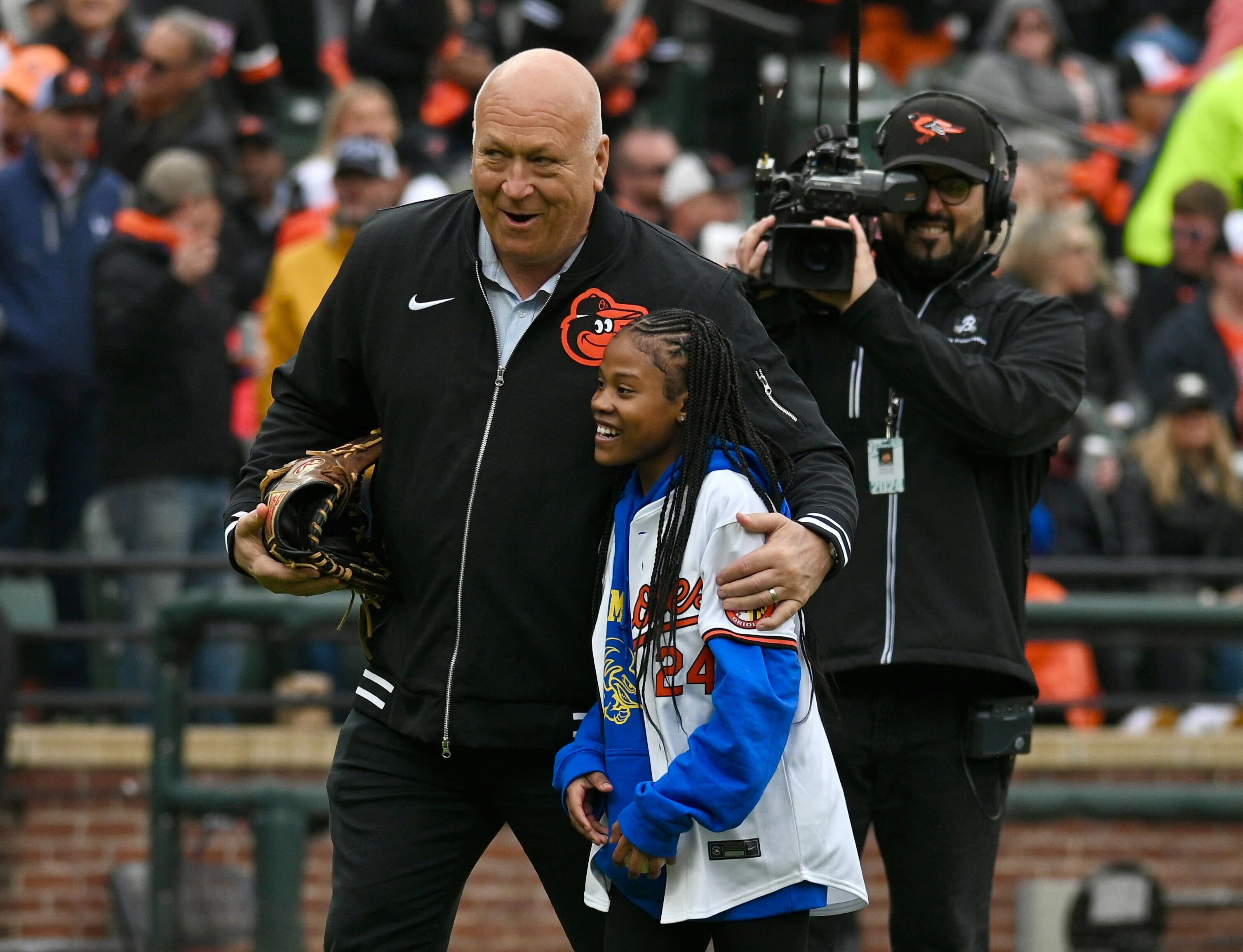 March 28, 2024: Former Orioles player Cal Ripken Jr. joins Aubree Singletary, who threw out the ceremonial first pitch, on the field during opening day ceremonies at Oriole Park at Camden Yards. (Kenneth K. Lam/Staff)