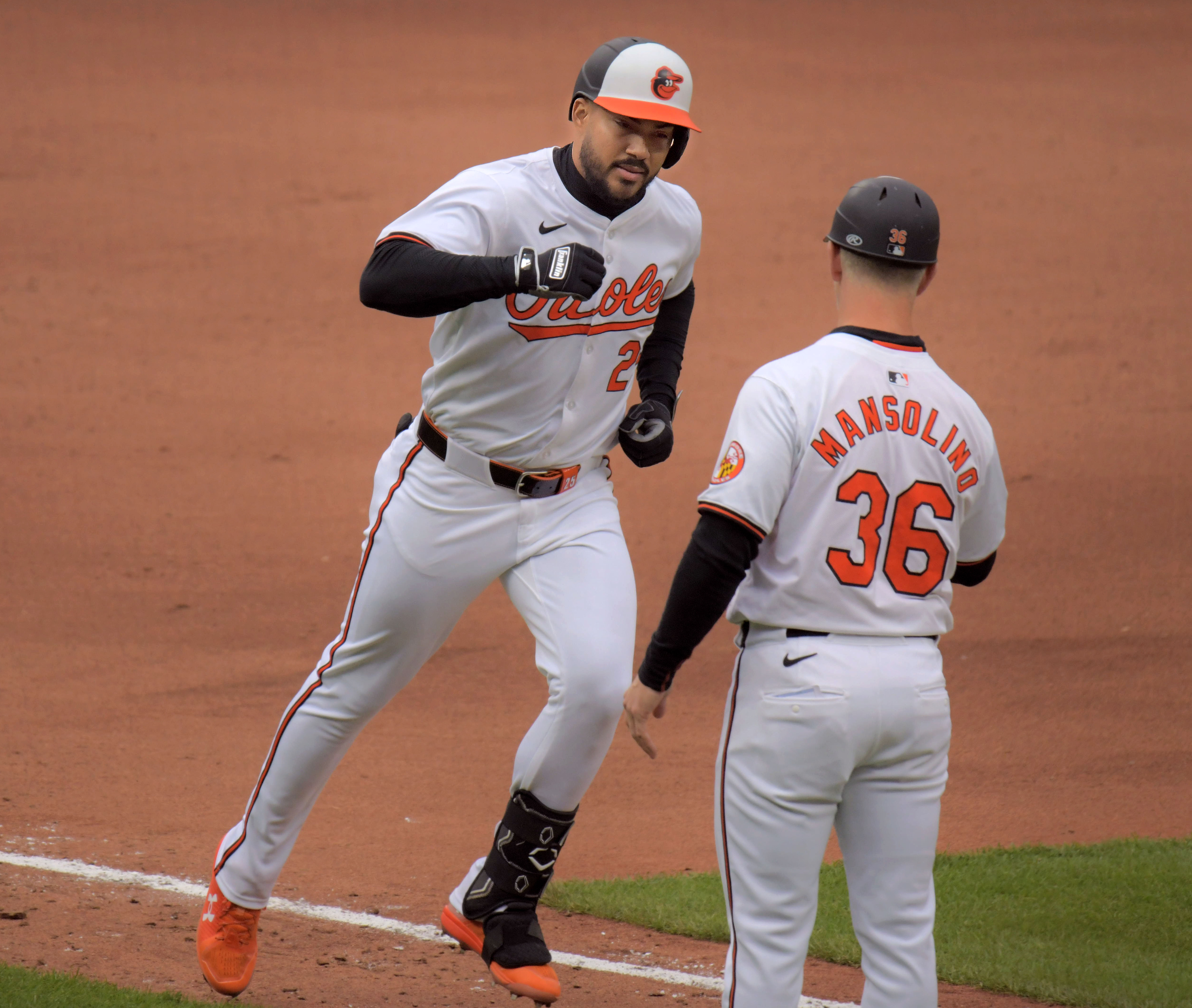 Mar 28, 2024: Baltimore Orioles batter Anthony Santander rounds the bases after hammering a two-run home run, getting congratulated by third base coach Tony Mansolino during opening day of Major League Baseball at Oriole Park at Camden Yards. (Karl Merton Ferron/Staff)