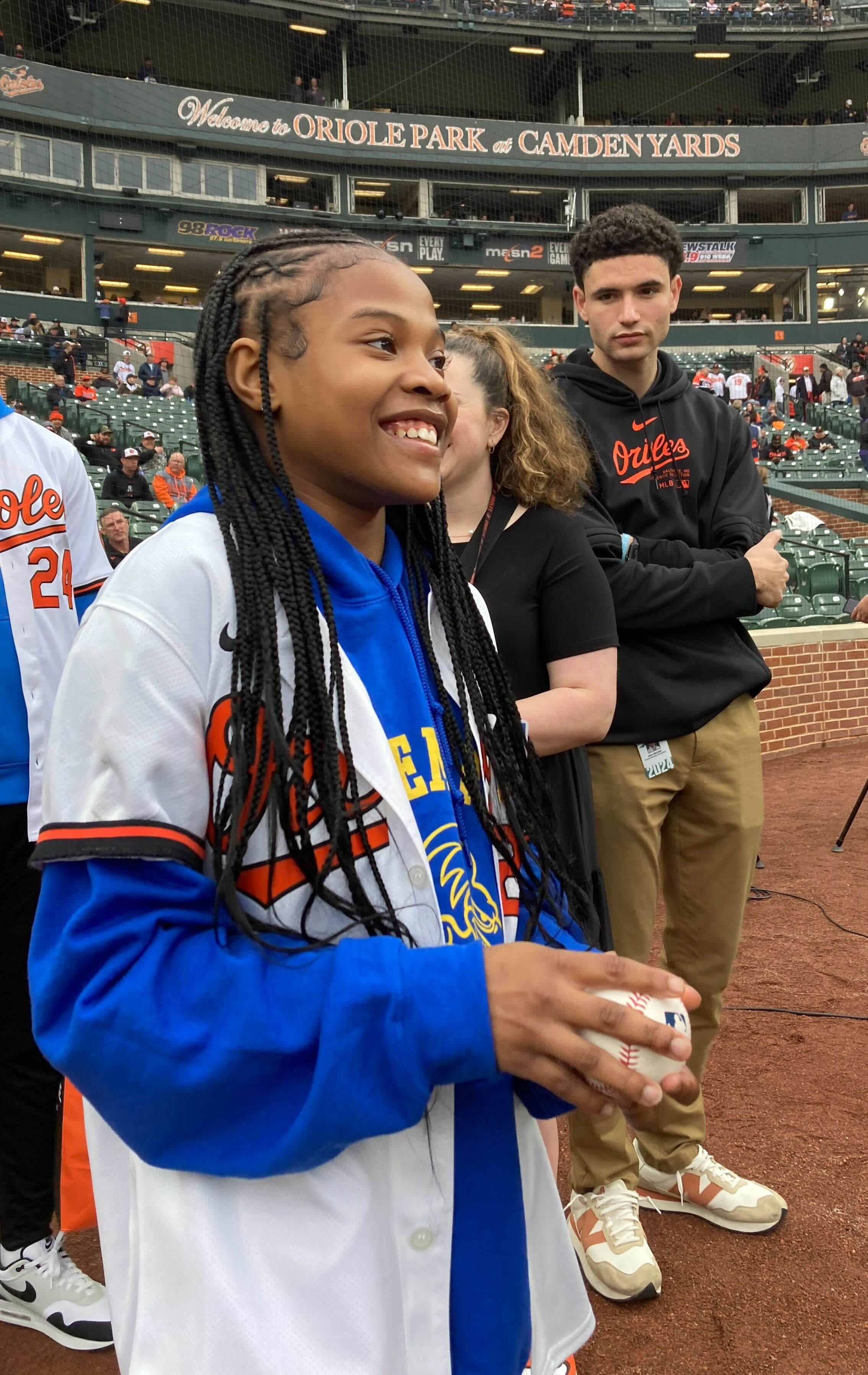 March 28, 2024: Aubree Singletary, 10 of E. Baltimore smiles while waiting to throw the first pitch to Cal Ripken Jr.. (Karl Merton Ferron/Staff)