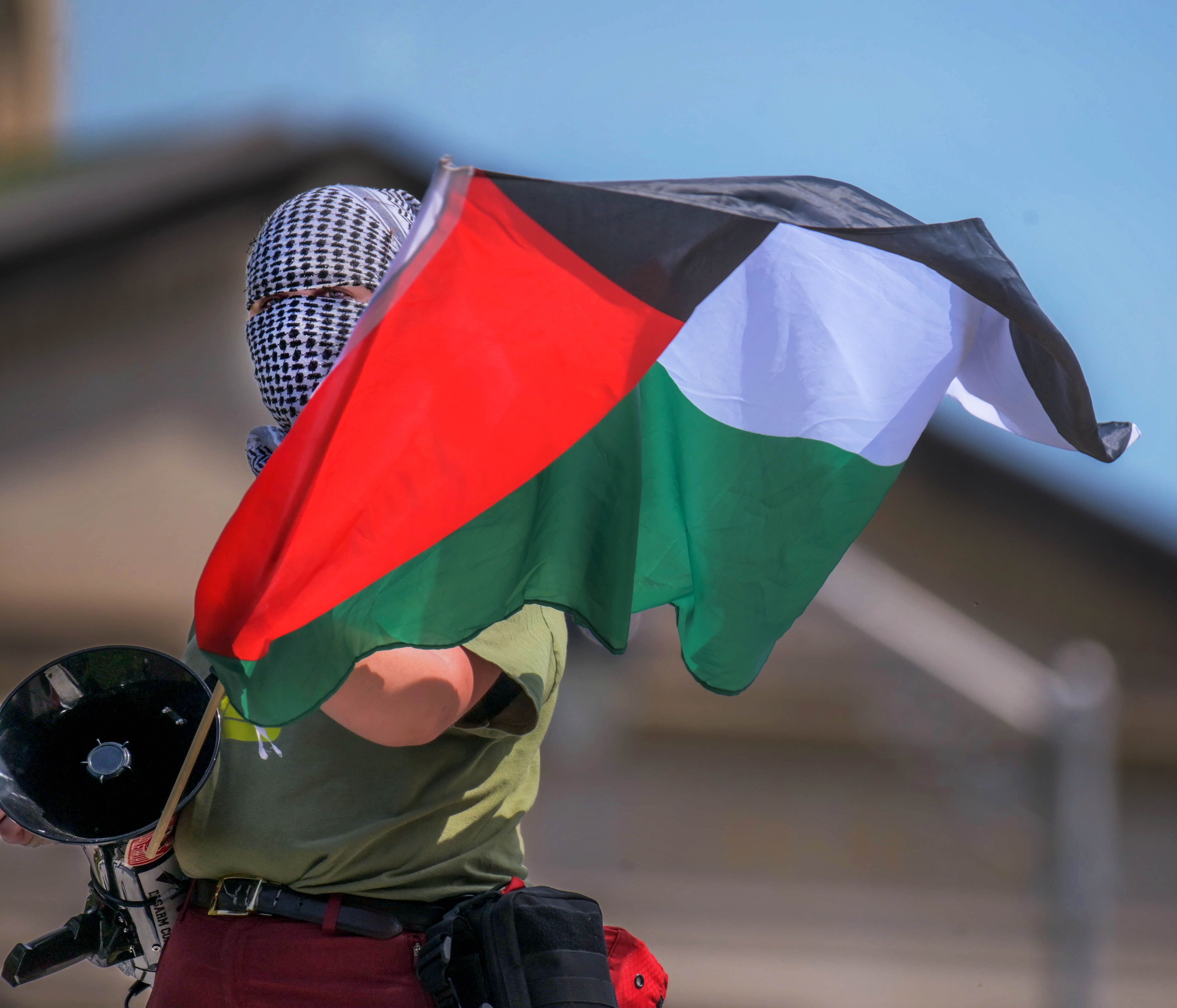 An organizer holds the flag of Palestine during another day of protests at the Johns Hopkins Homewood campus,  denouncing Israel's continued attacks against Palestinian refugees in Gaza. (Karl Merton Ferron/Staff)