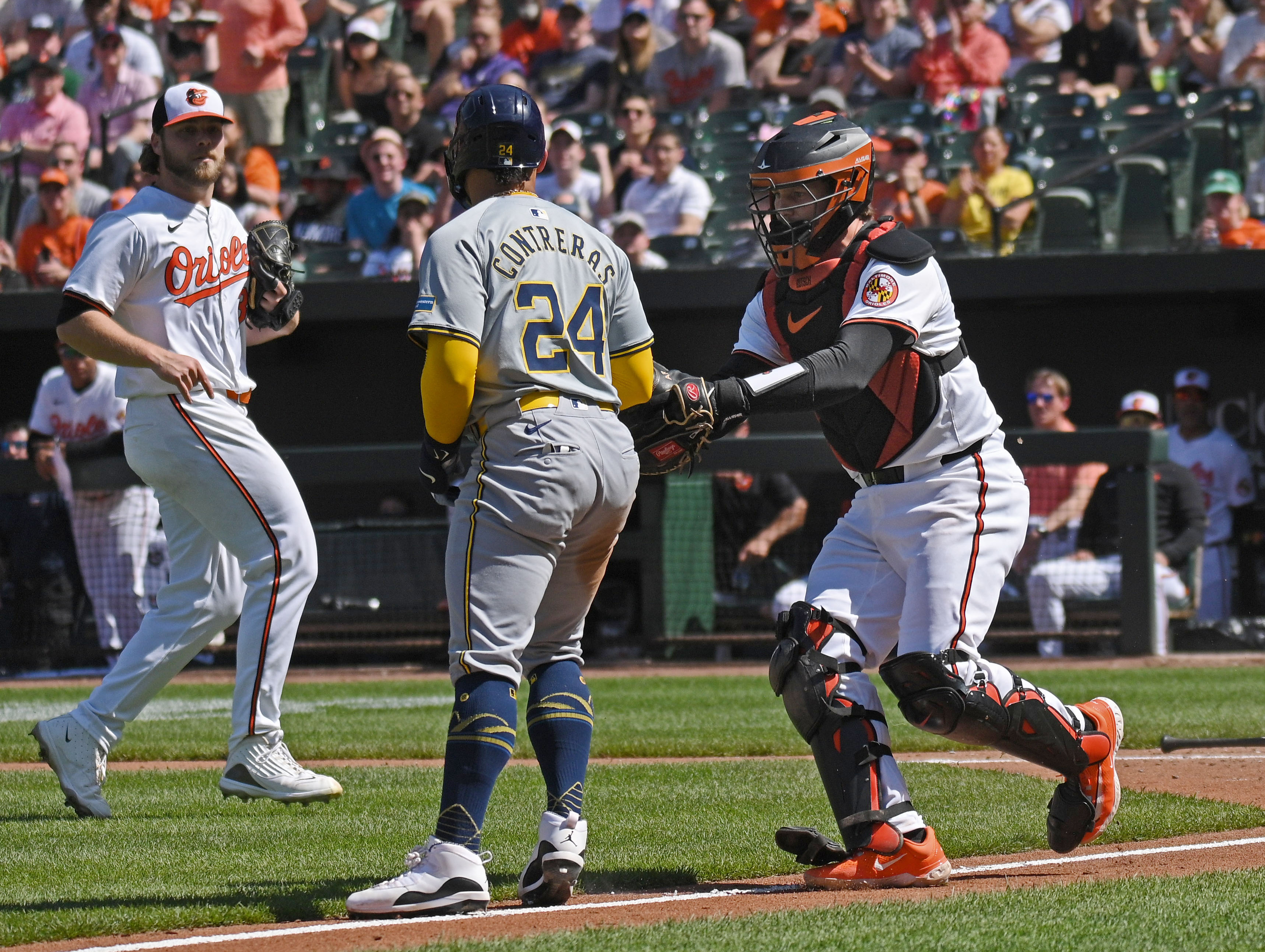 Orioles catcher Adley Rutschman, right, tags out Brewers William Contreras in a run down in the fifth inning. The Orioles defeated the Brewers 6-4 at Oriole Park at Camden Yards. (Kenneth K. Lam/Staff)