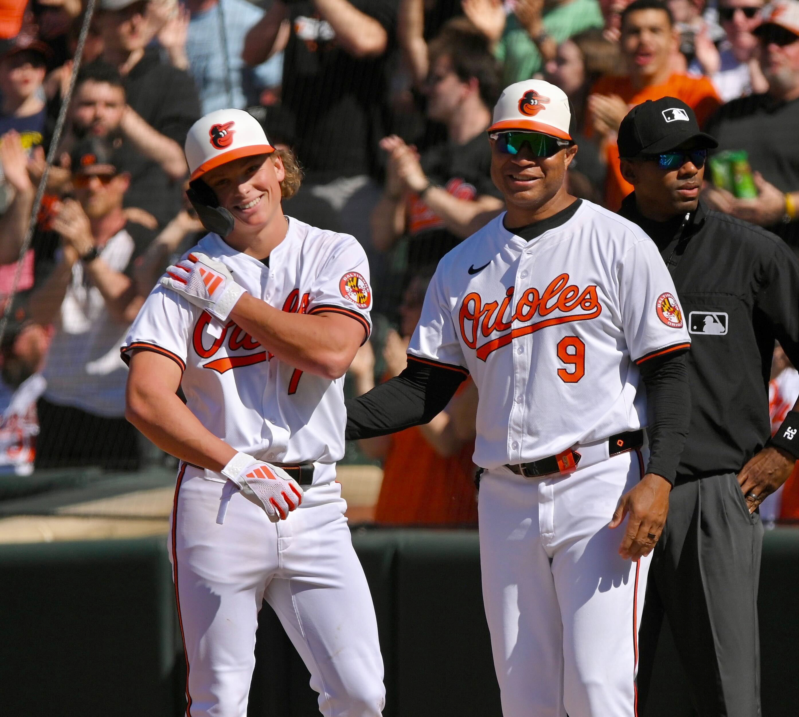 Orioles' Jackson Holliday reacts with first base coach, Anthony Sanders, after his first MLB hit in a game against the Milwaukee Brewers. (Kenneth K. Lam/staff)