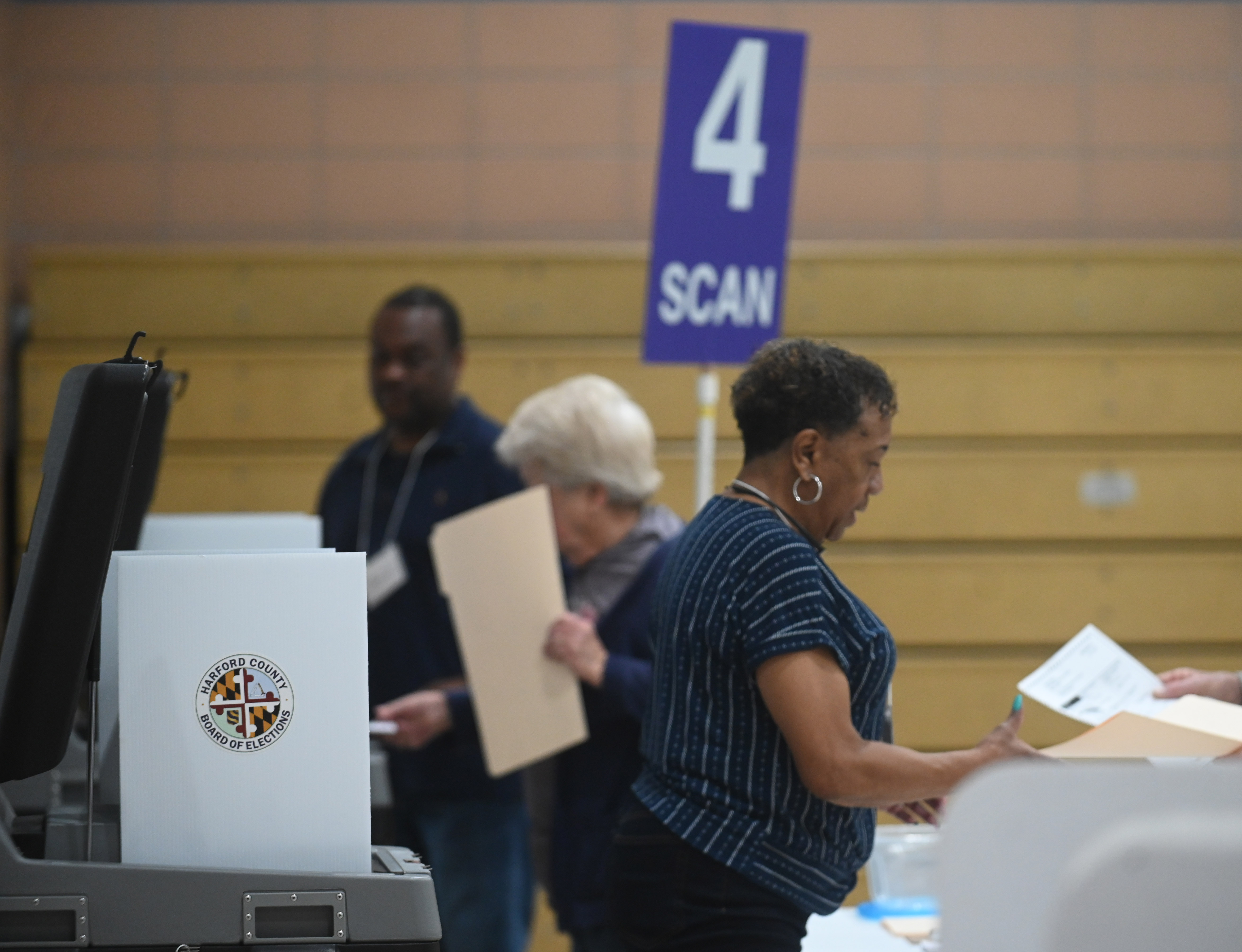 Election officials help voters scan their ballots at the polling location at Church Creek Elementary for Maryland's primary election on Tuesday. (Brian Krista/staff photo)