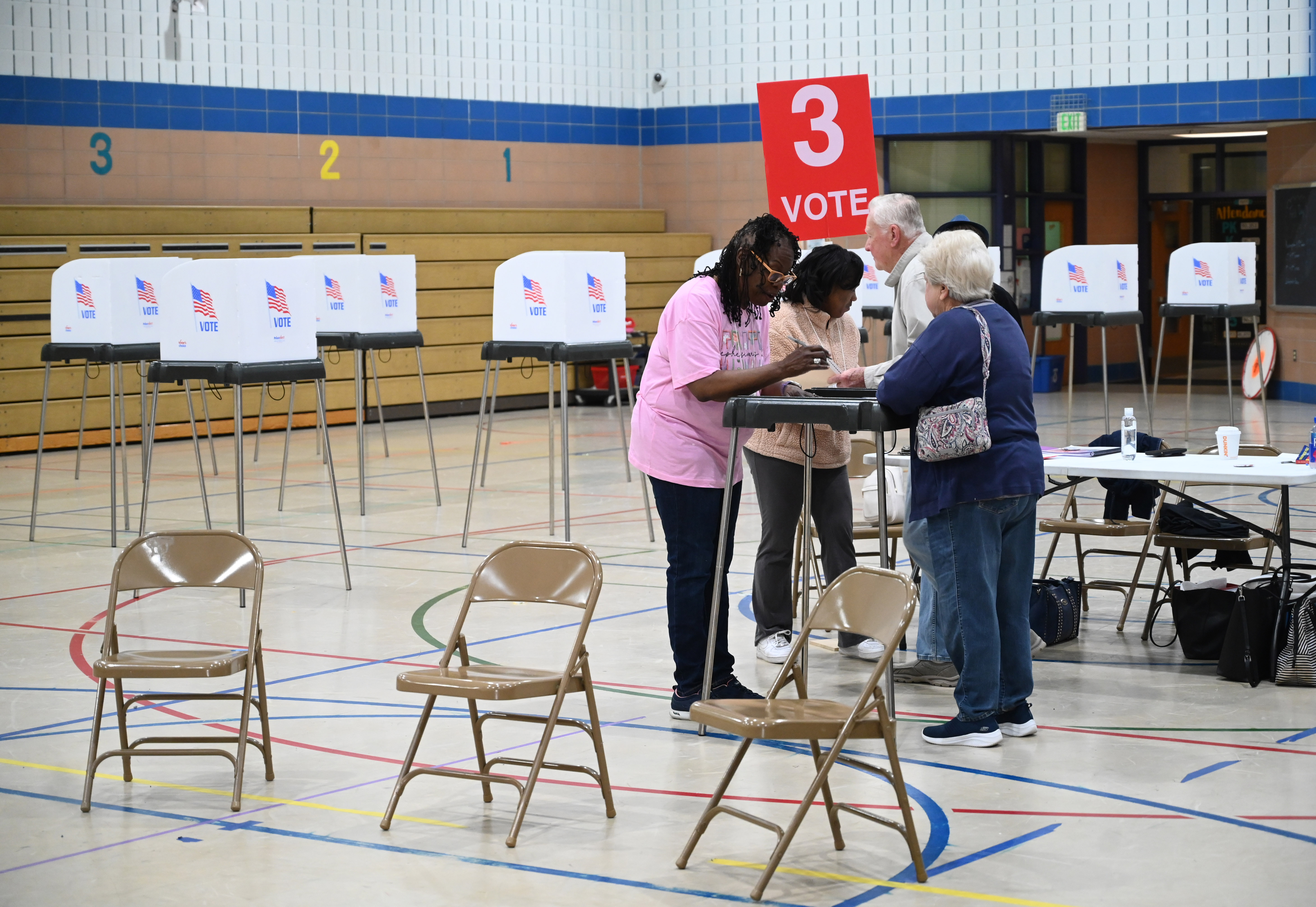 Election officials help voters prepare to fill out their ballots at the polling location at Church Creek Elementary for Maryland's primary election on Tuesday. (Brian Krista/staff photo)