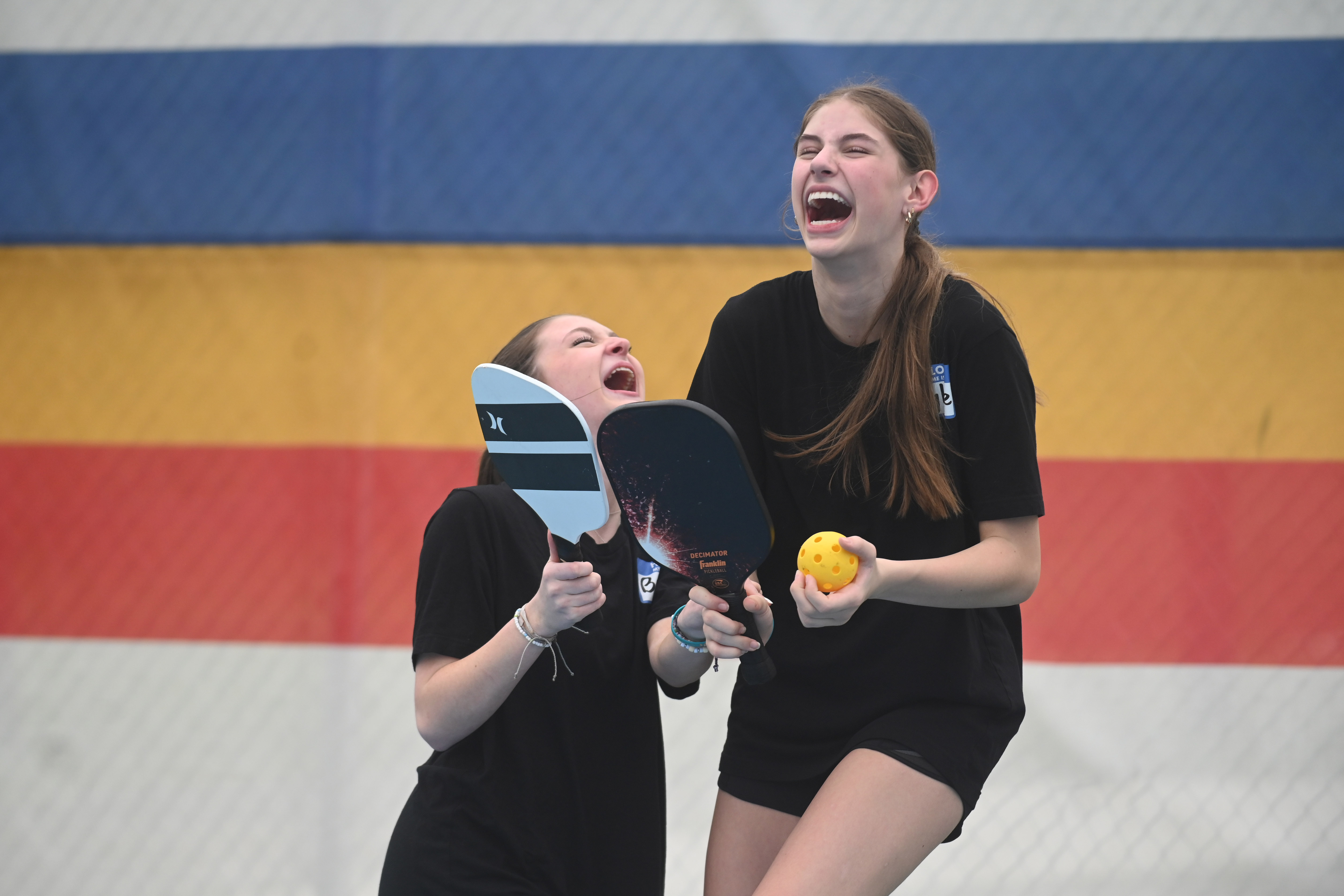 Freshmen Ryann Hoke, left, and Brenna Maas laugh together after giving up a point to their opponents during a pickleball tournament at Coppermine 4 Seasons on Tuesday. The tournament was organized by Manchester Valley High School juniors Brady Bonney and Leigh Hoke to raise money and support for Morgan's Message, a nonprofit supporting student-athlete mental health initiatives. (Brian Krista/staff photo)