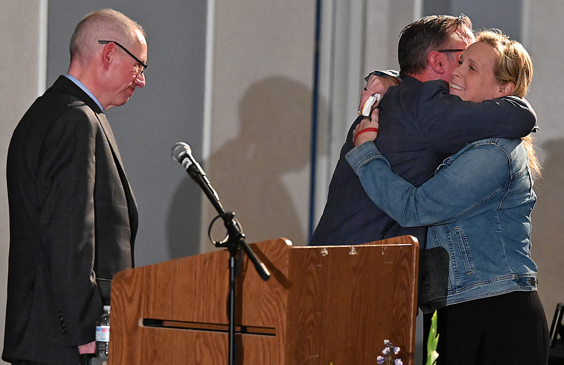 Margie Neighoff, Peer Recovery Coach at Carroll Hospital Center, is hugged by Tim Weber after receiving the "Bob Kirkland Award" at the 9th Annual Drug Overdose and Prevention Vigil Tuesday at Portico at St. John in Westminster. (Jeffrey F. Bill/Staff photo)