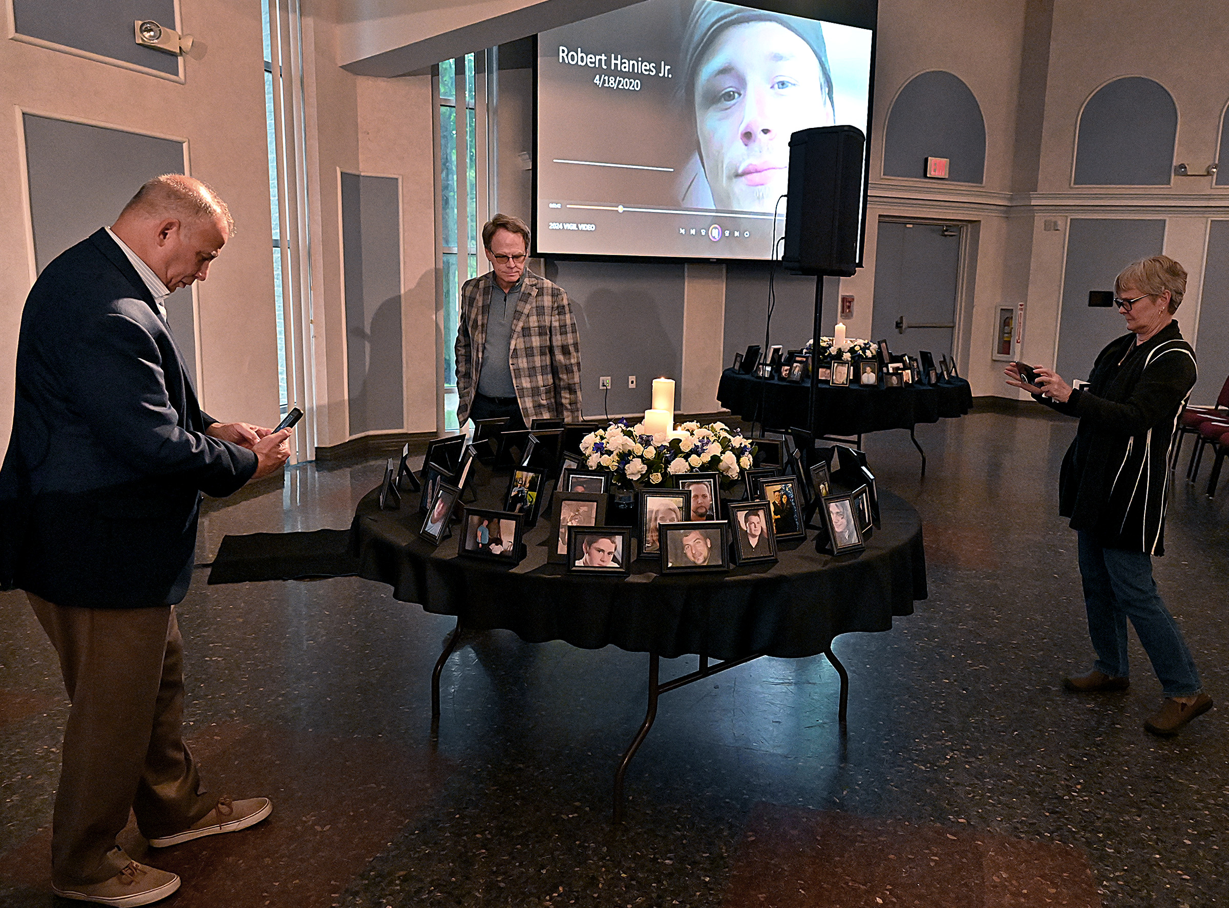 County Commissioner, Ed Rothstein, District 5, and others look at pictures of those lost to overdose prior to the start of the vigil. The State's Attorney's office hosted Carroll County's 9th Annual Drug Overdose and Prevention Vigil Tuesday at Portico at St. John in Westminster. (Jeffrey F. Bill/Staff photo)