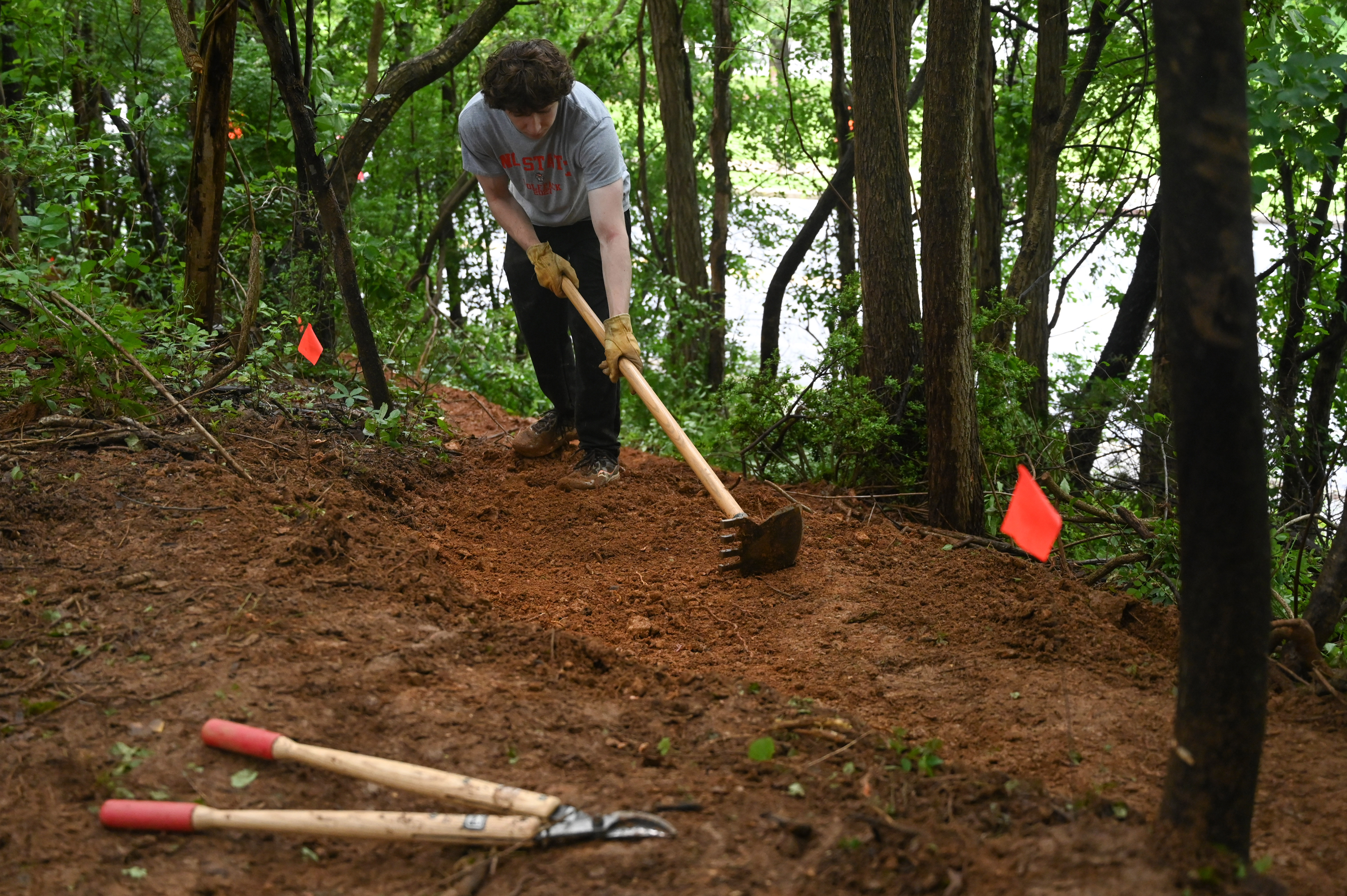 Colby Jaeb works on grading a portion of the path as a group of volunteers make progress in the creation of a new bike trail, Windy Ridge Trails, at Mount Airy's East West Park on Saturday. (Brian Krista/staff photo)