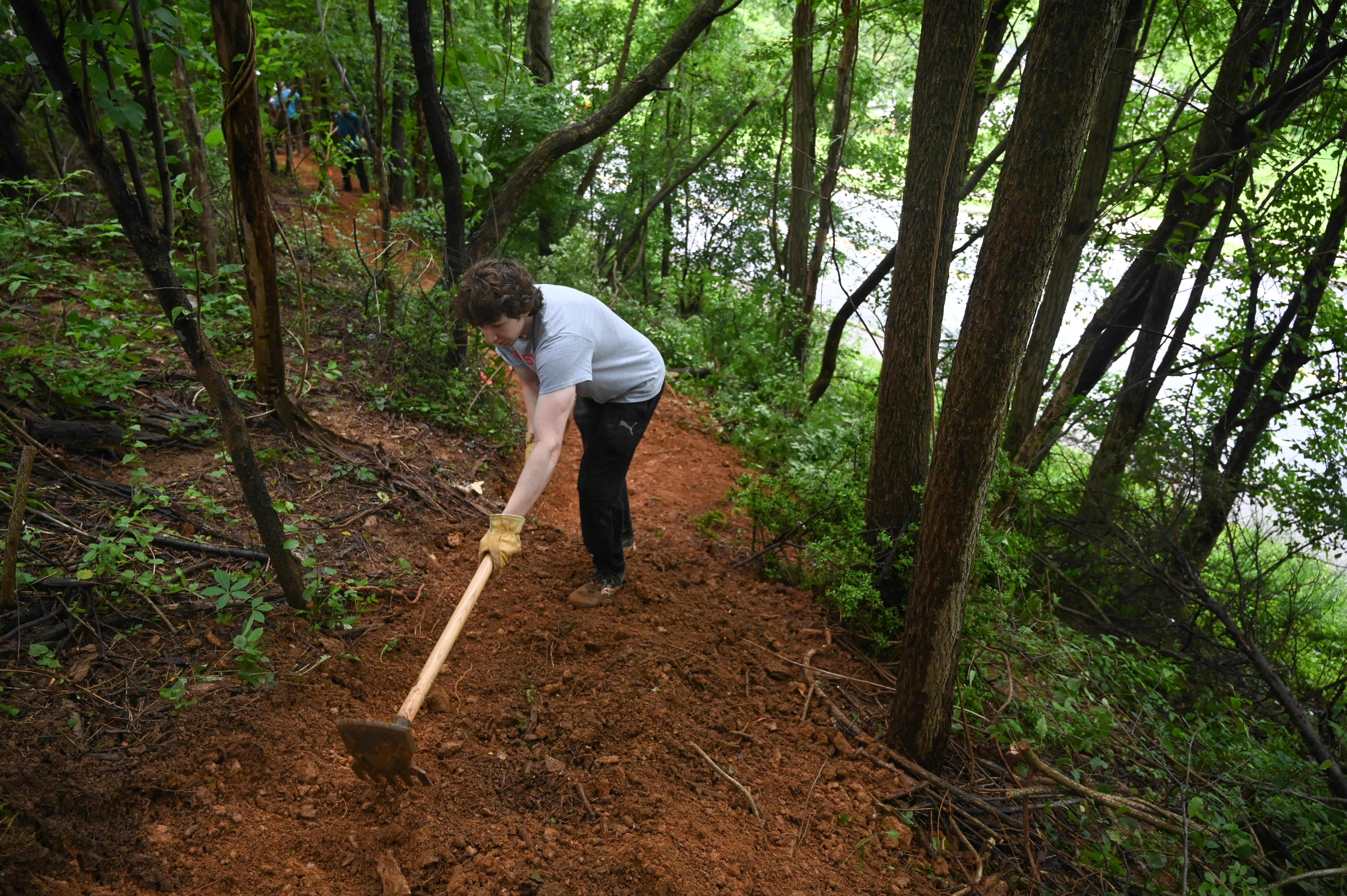 Colby Jaeb works on grading a portion of the path as a group of volunteers make progress in the creation of a new bike trail, Windy Ridge Trails, at Mount Airy's East West Park on Saturday. (Brian Krista/staff photo)