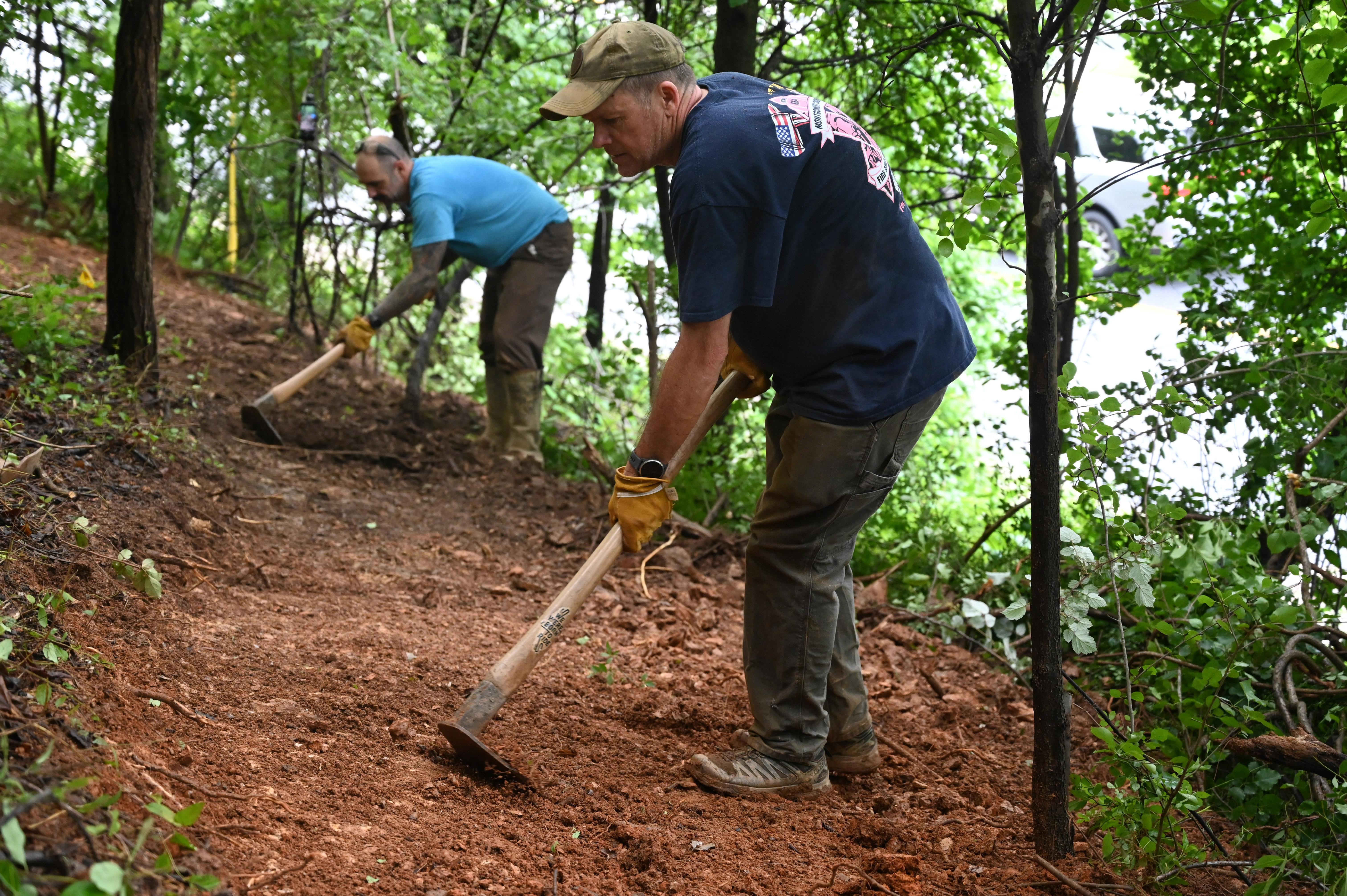 Patrick Ellis, trail liaison, is joined by Dan Clark, left, and other volunteers as they make progress in the creation of a new bike trail, Windy Ridge Trails, at Mount Airy's East West Park on Saturday. (Brian Krista/staff photo)