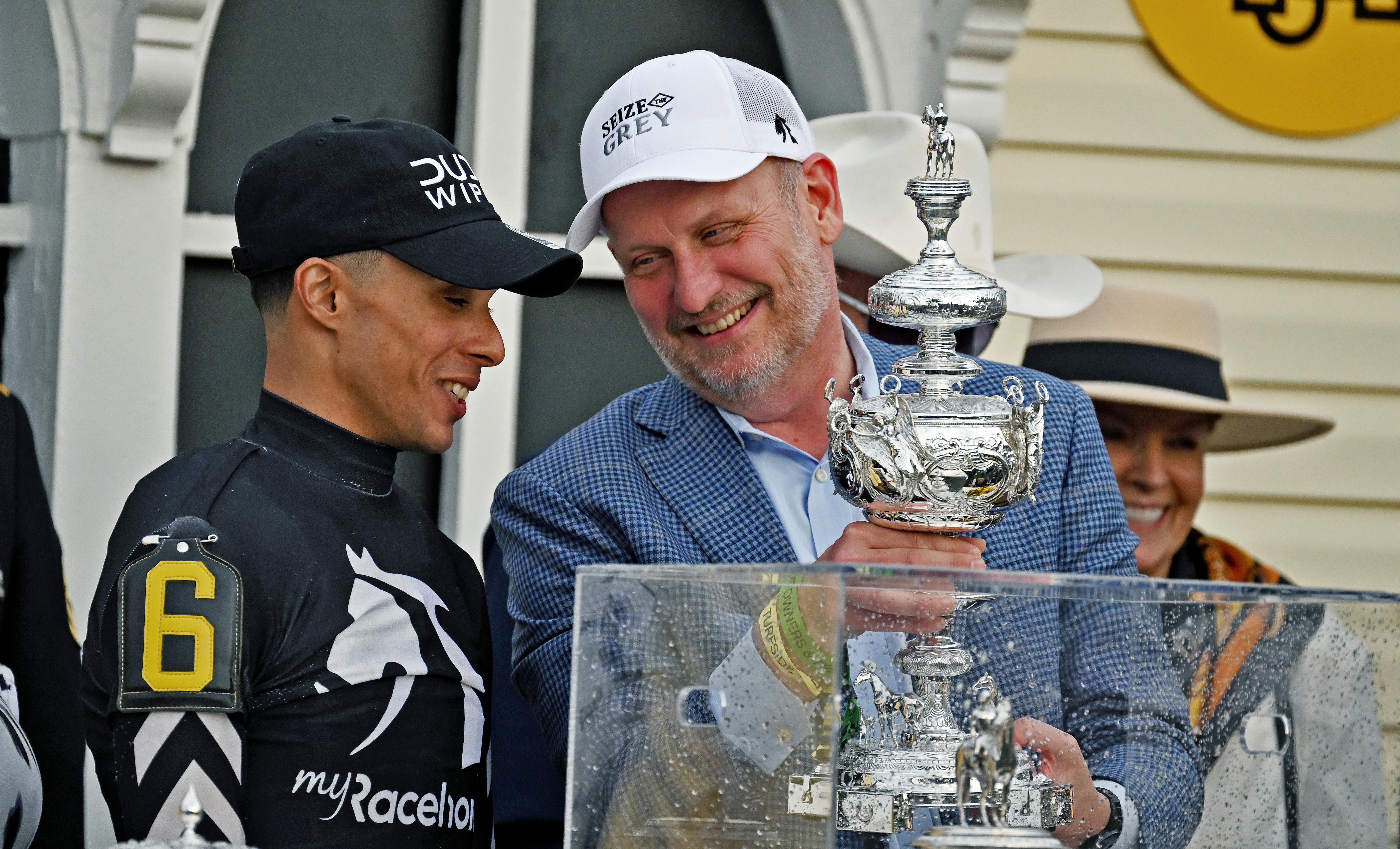 Winning Preakness jockey Jaime Torres and Michael Behrens, founder of MyRacehorse, share a smile as Behrens holds the Woodlawn Vase. (Kim Hairston/Staff)