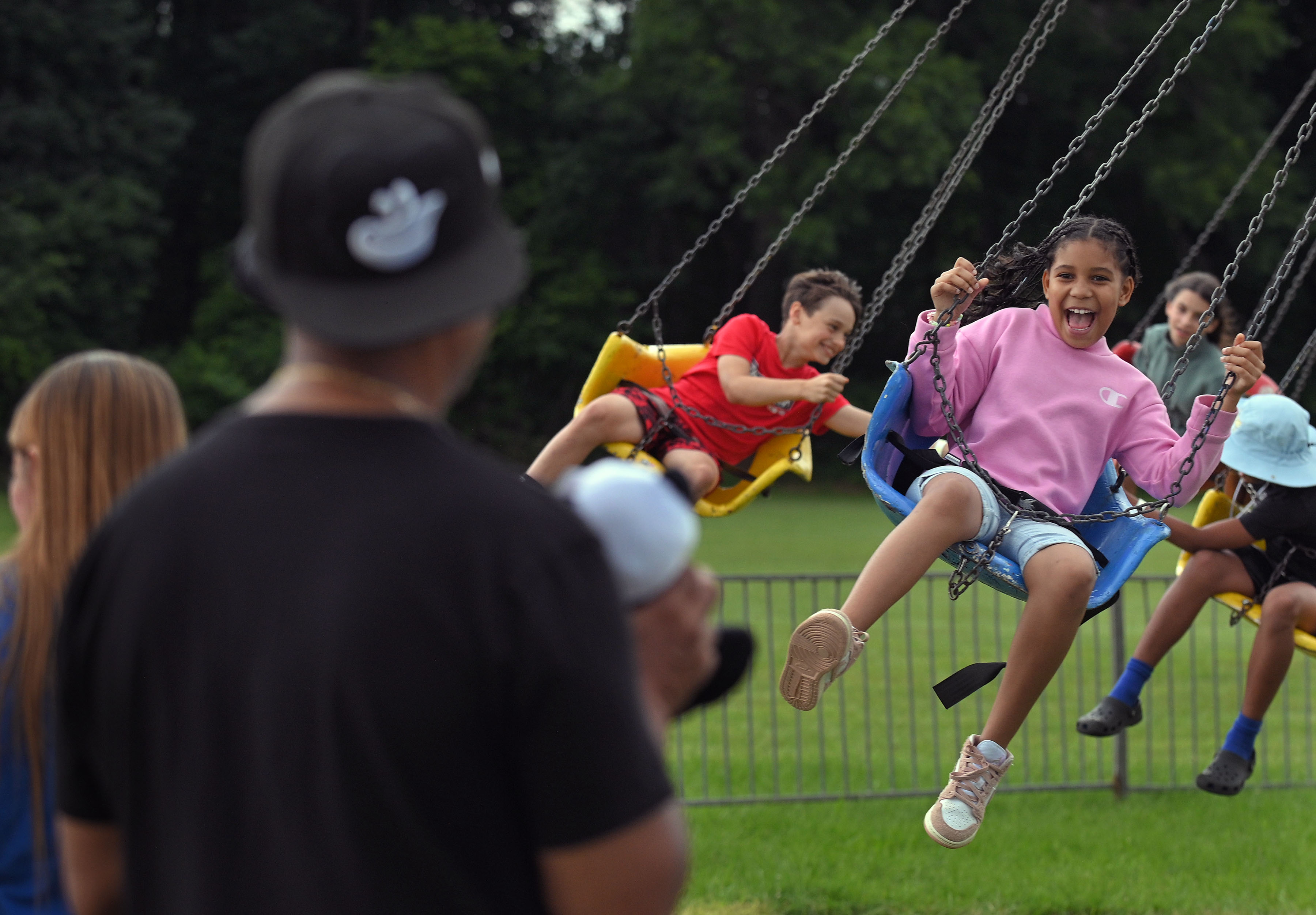 Jernee Hardison, 9, right, of Randallstown, smiles at dad Dwayne, left, while riding the Swinger during Sykesville Freedom District Fire Department's Annual firemen's carnival which runs from June 8-15. (Kenneth K. Lam/Staff)