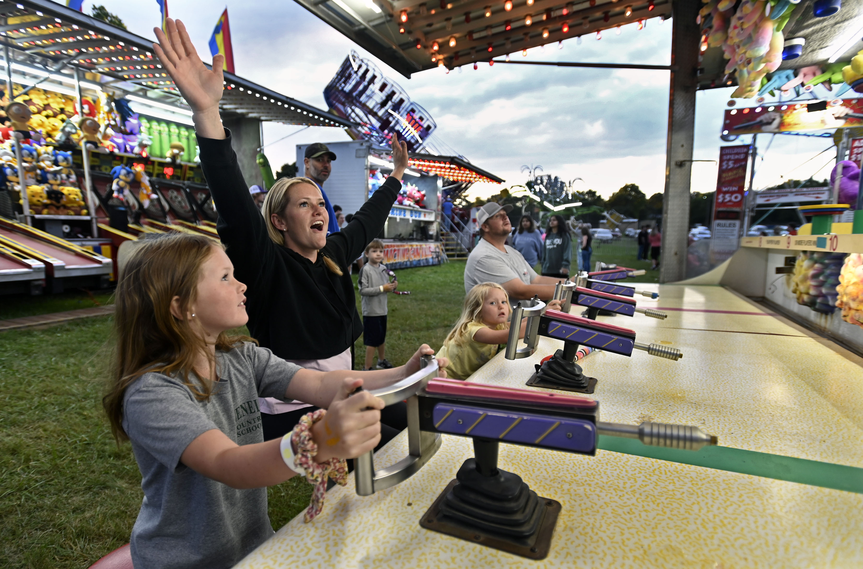 Kathryn Orndorff, second left, of Clarksville, reacts after beating her family, from left, daughters Oeyton, 7, Reagan, 3, and husband Ryan in a water gun game during Sykesville Freedom District Fire Department's Annual firemen's carnival which runs from June 8-15. (Kenneth K. Lam/Staff)