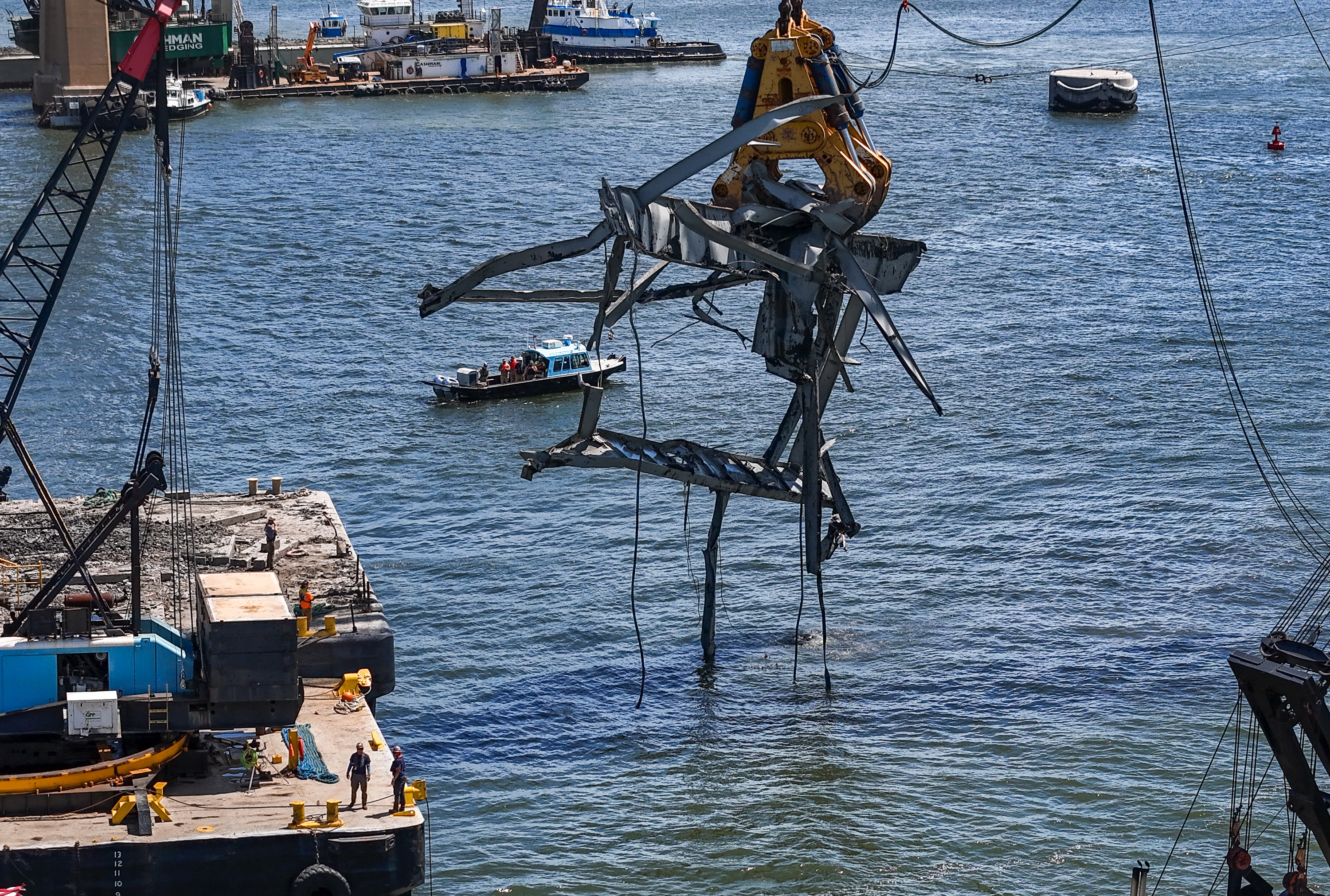 A large piece of the Francis Scott Key Bridge is lifted from the bottom of the Federal Channel by the enormous claw attached to the Chesapeake 1000 Friday morning.. (Jerry Jackson/Staff)