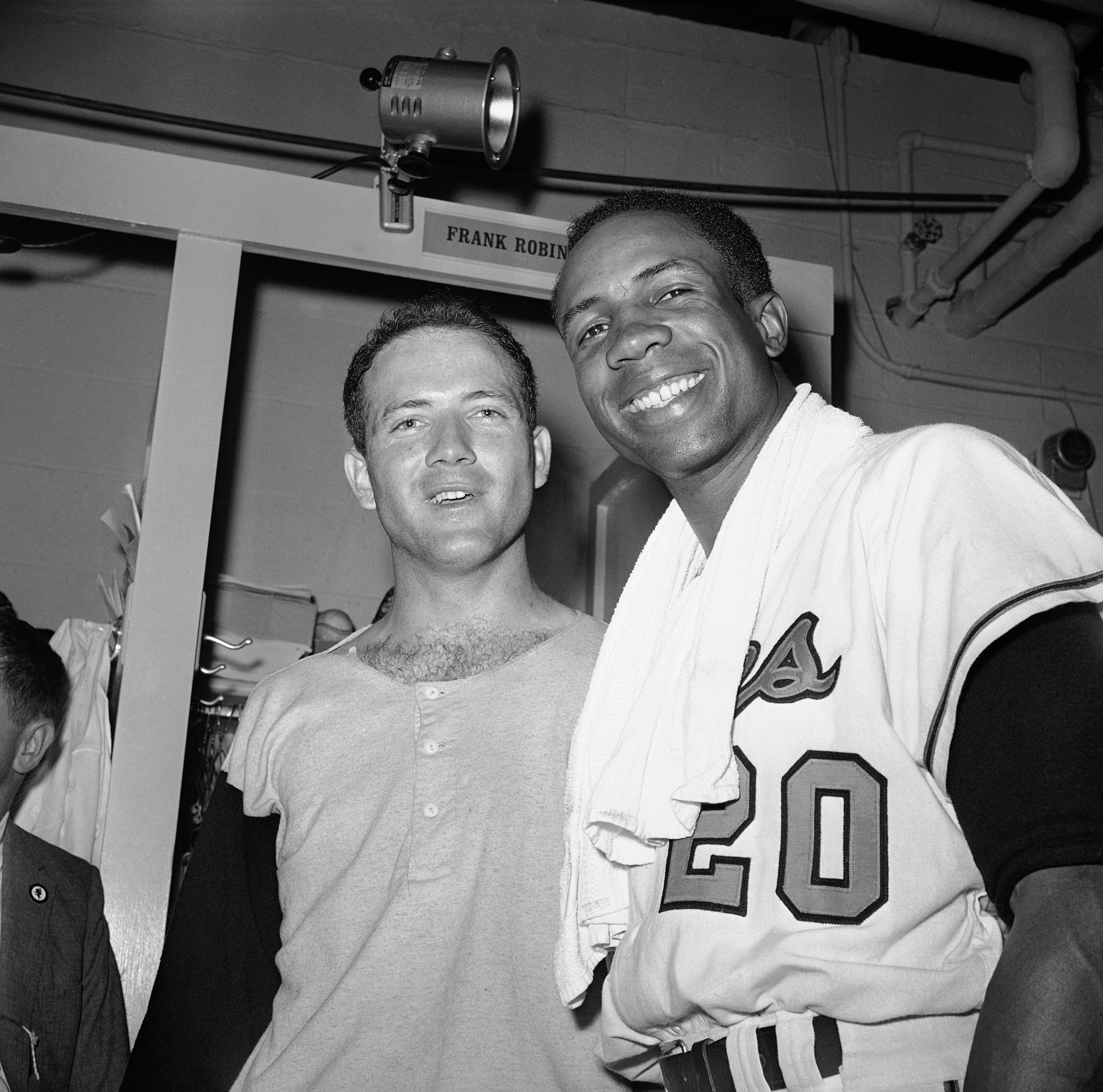 In this Oct. 9, 1966, file photo, pitcher Dave McNally, left, and right fielder Frank Robinson pose in the clubhouse after the host Orioles defeated the Los Angeles Dodgers to win the World Series.