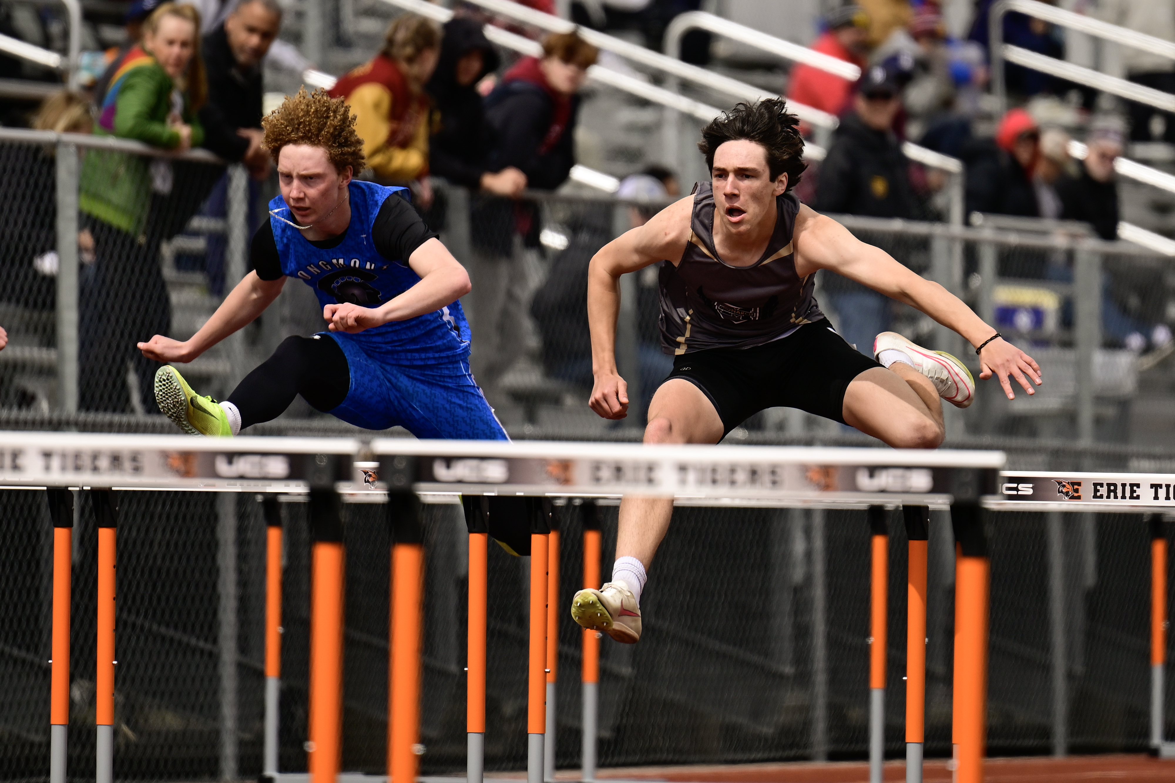 From left: Longmont's Malcom Teagan and Monarch's Brek Hoenninger race to the finish in the 110 Meter Hurdles race at the Erie Twilight Invitational track and field meet on Friday, March 29, 2024. (Matthew Jonas/Staff Photographer)