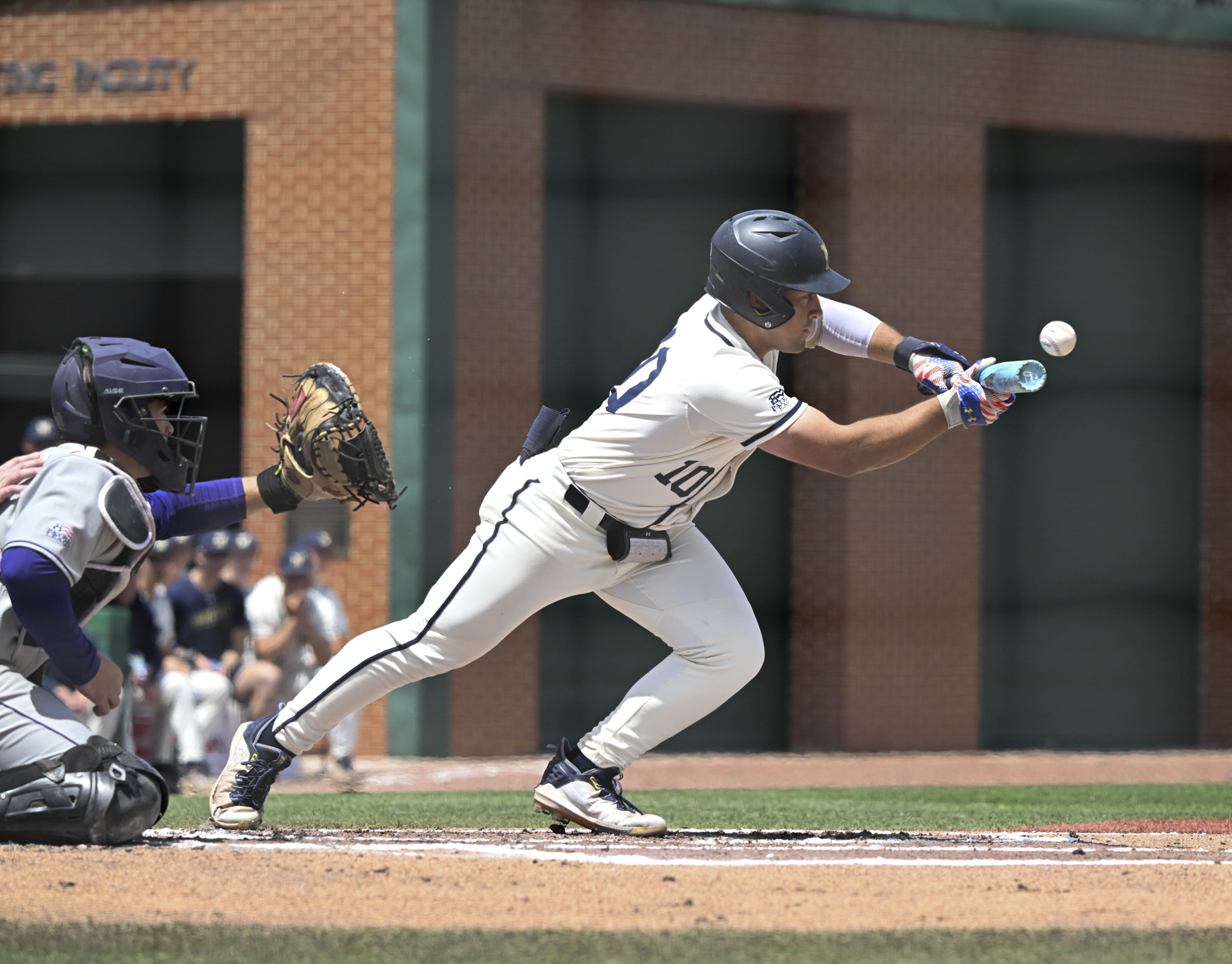 Navy shortstop Eduardo Diaz lays down a sacrifice bunt during Sunday's doubleheader against Holy Cross. (Debbie Latta/Navy Athletics)