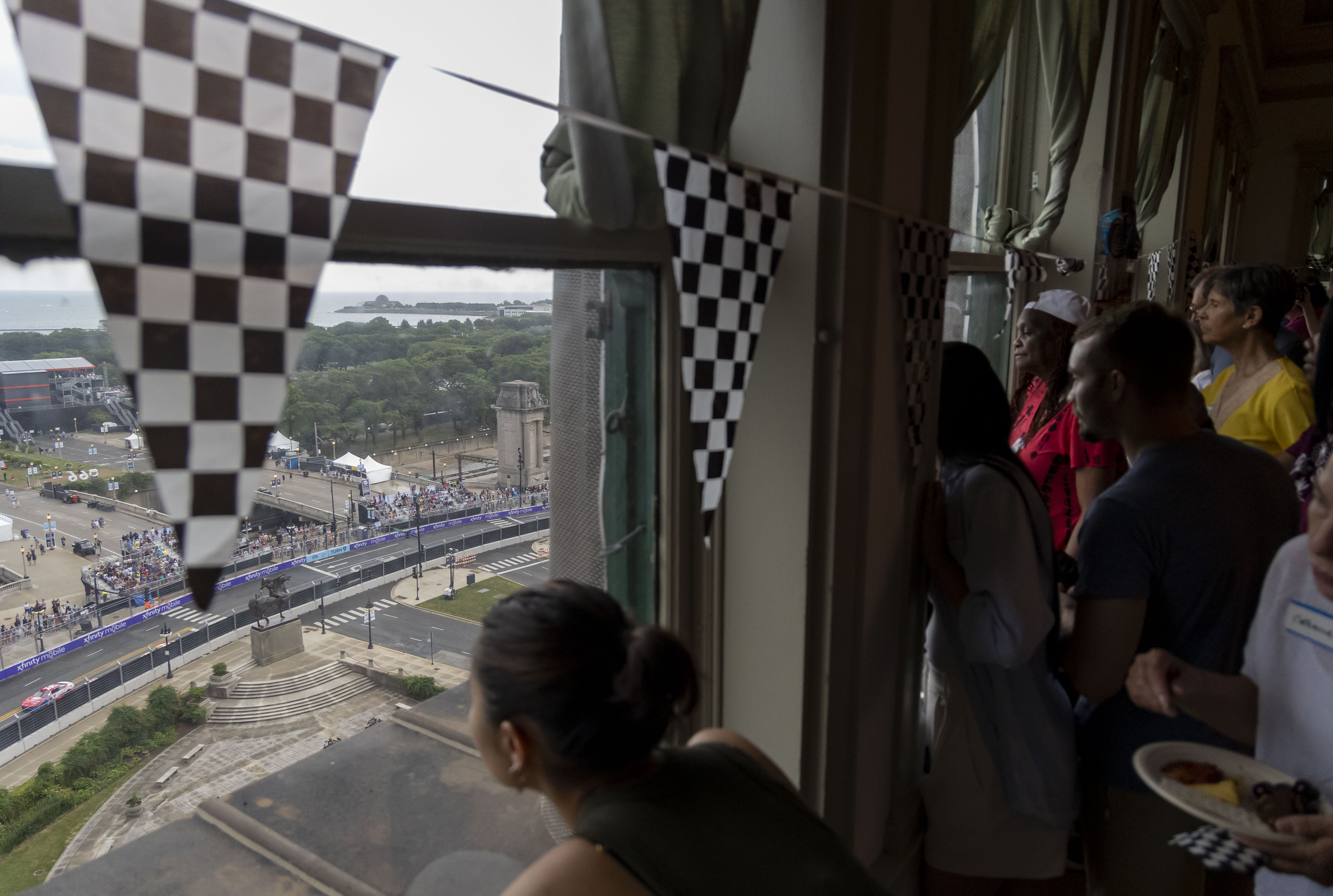 People watch from windows along Michigan Avenue during the NASCAR Chicago Street Race on Sunday, July 7, 2024. (Brian Cassella/Chicago Tribune)