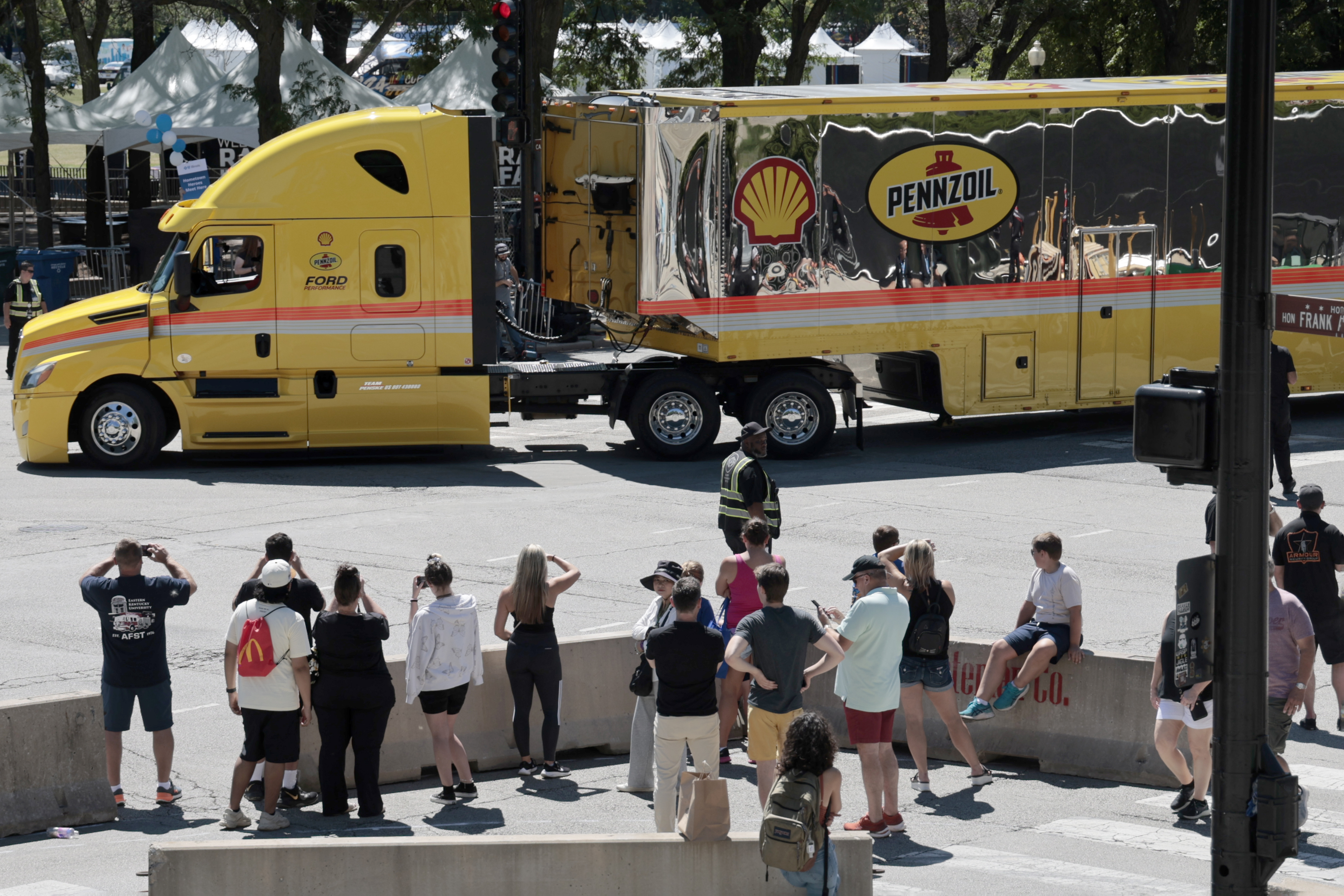 Crowds look on at Columbus Drive and Monroe, Friday, July 5, 2024, as trucks arrive with race cars to be unloaded off trucks in preparation for the NASCAR race. (Antonio Perez/Chicago Tribune)