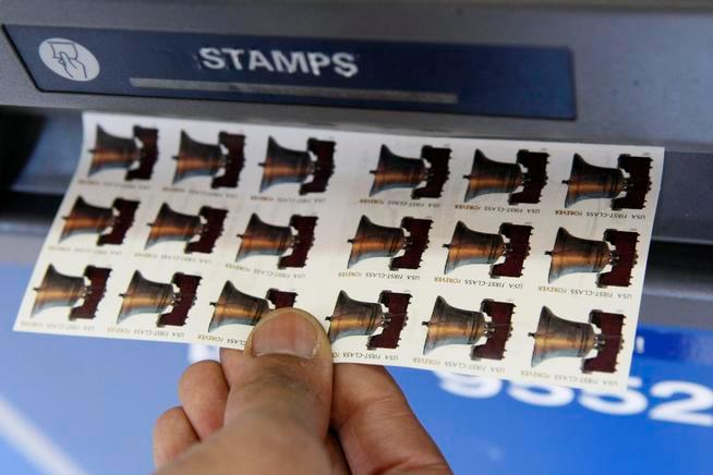 A United States Postal Service employee purchases Forever stamps from an automated postage machine at the main post office, Thursday, April 9, 2009 in New York. The price of first class stamps is going from 42 cents to 44 cents on May 11, but postal customers can use their Forever stamps without adding additional postage.