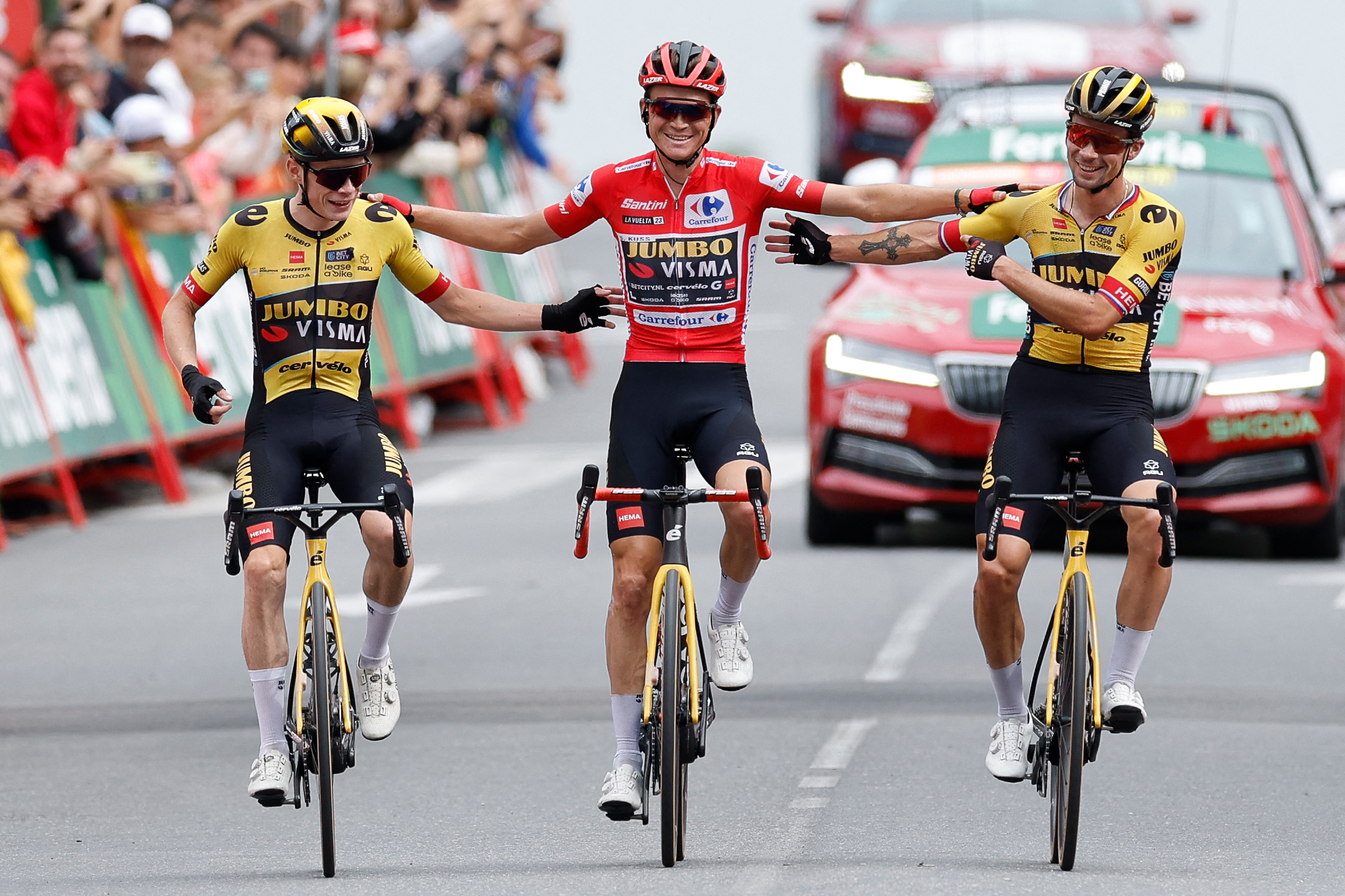 Team Jumbo-Visma's US rider Sepp Kuss, wearing the overall leader jersey (C) celebrates with Team Jumbo-Visma's Danish rider Jonas Vingegaard (L) and Team Jumbo's Slovenian rider Primoz Roglic as he crosses the finish line of the stage 20 of the 2023 La Vuelta cycling tour of Spain, a 207,8 km race between Manzanares el Real and Guadarrama, on September 16, 2023. (Photo by Oscar DEL POZO / AFP) (Photo by OSCAR DEL POZO/AFP via Getty Images)