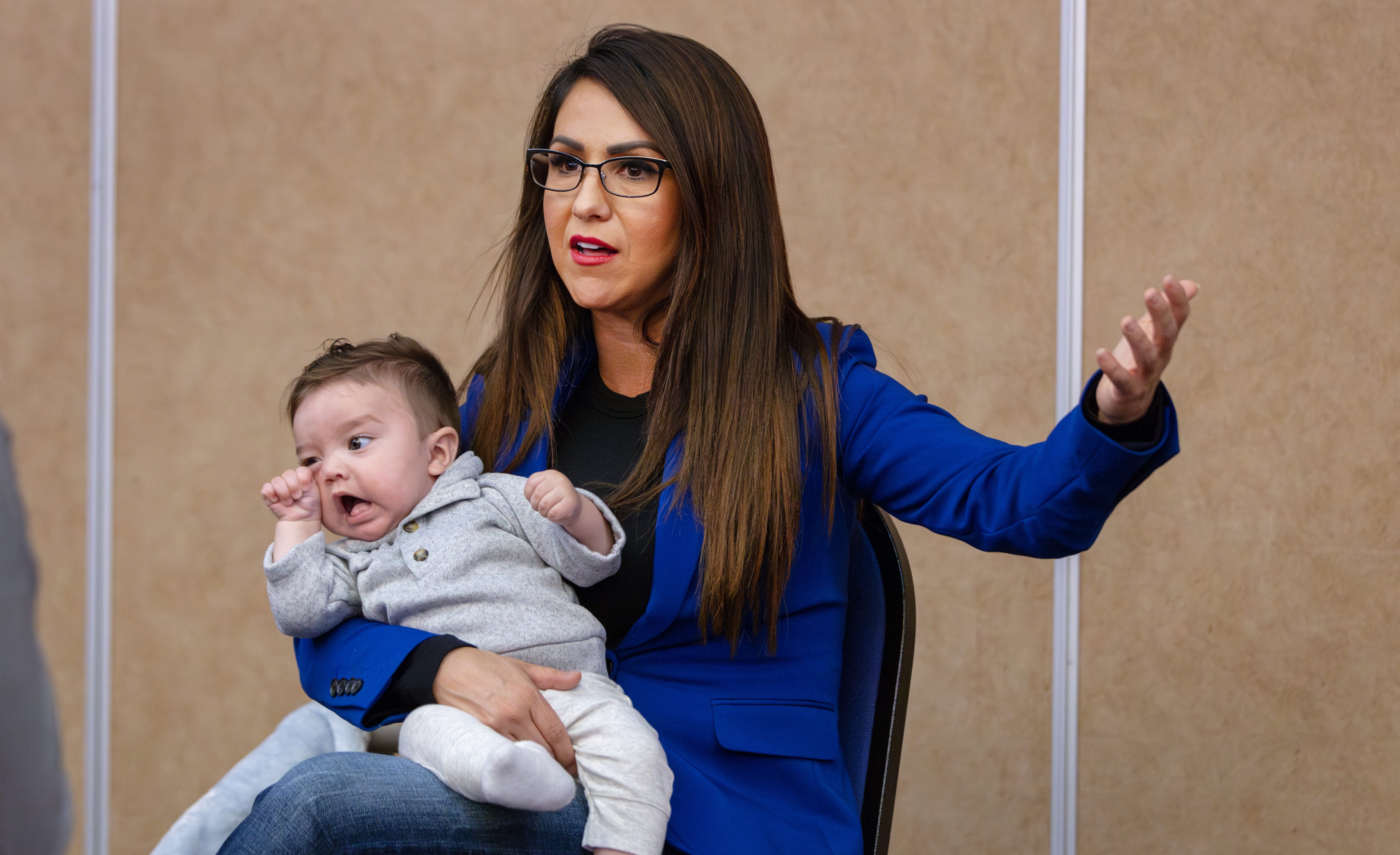 Rep. Lauren Boebert, center, is ionterviewed by a member of the media at the Montezuma County GOP's Lincoln Day Dinner held at the Ute Mountain Casino in Towaoc, Colorado Saturday as she holds her grandson Josiah Boebert. (Photo by Shaun Stanley/Special to The Denver Post)