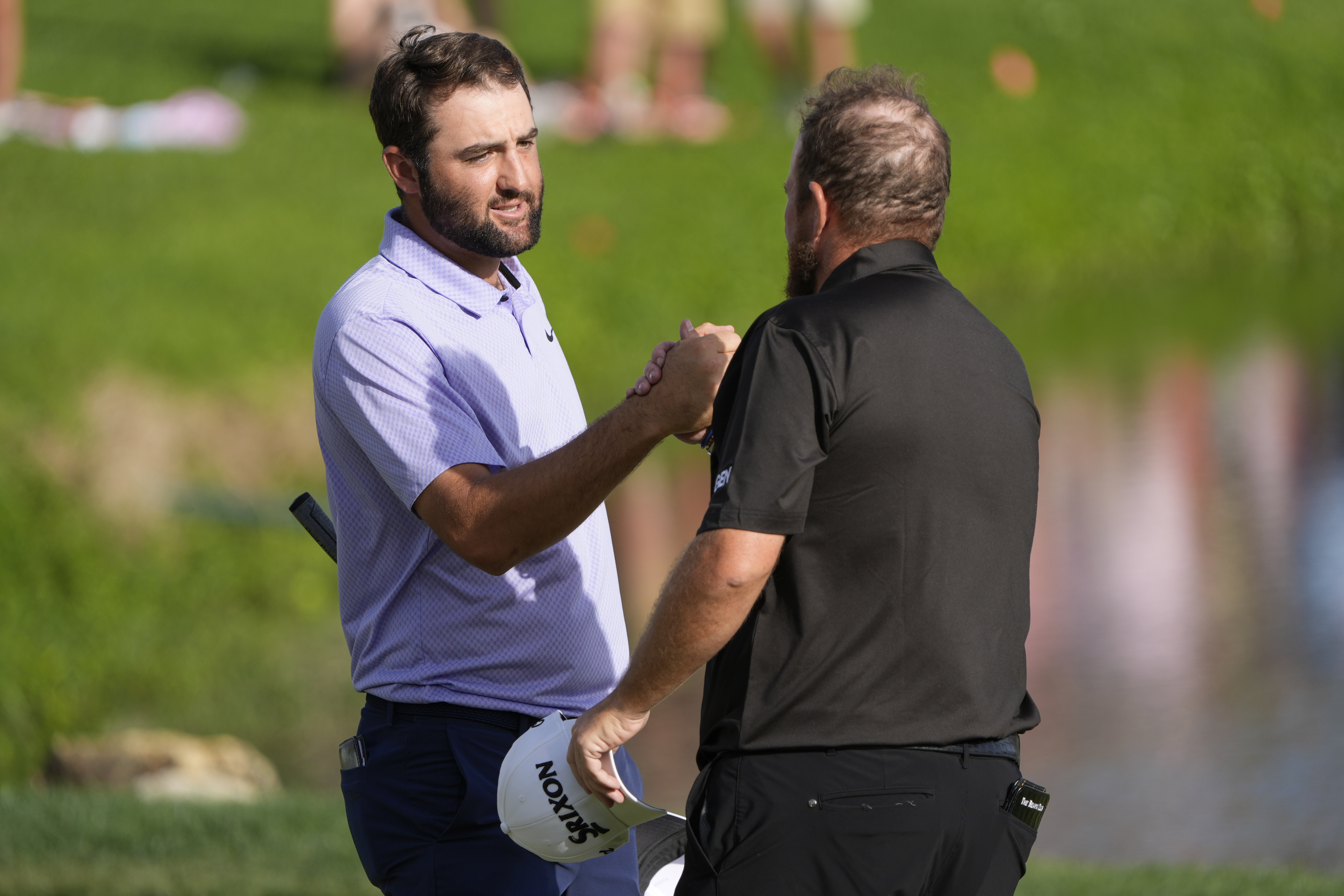 Scottie Scheffler, left, shakes hands with Shane Lowry, of Ireland, after they finished the final round of the Arnold Palmer Invitational March at Bay Hill Club and Lodge in Orlando. (AP Photo/John Raoux)