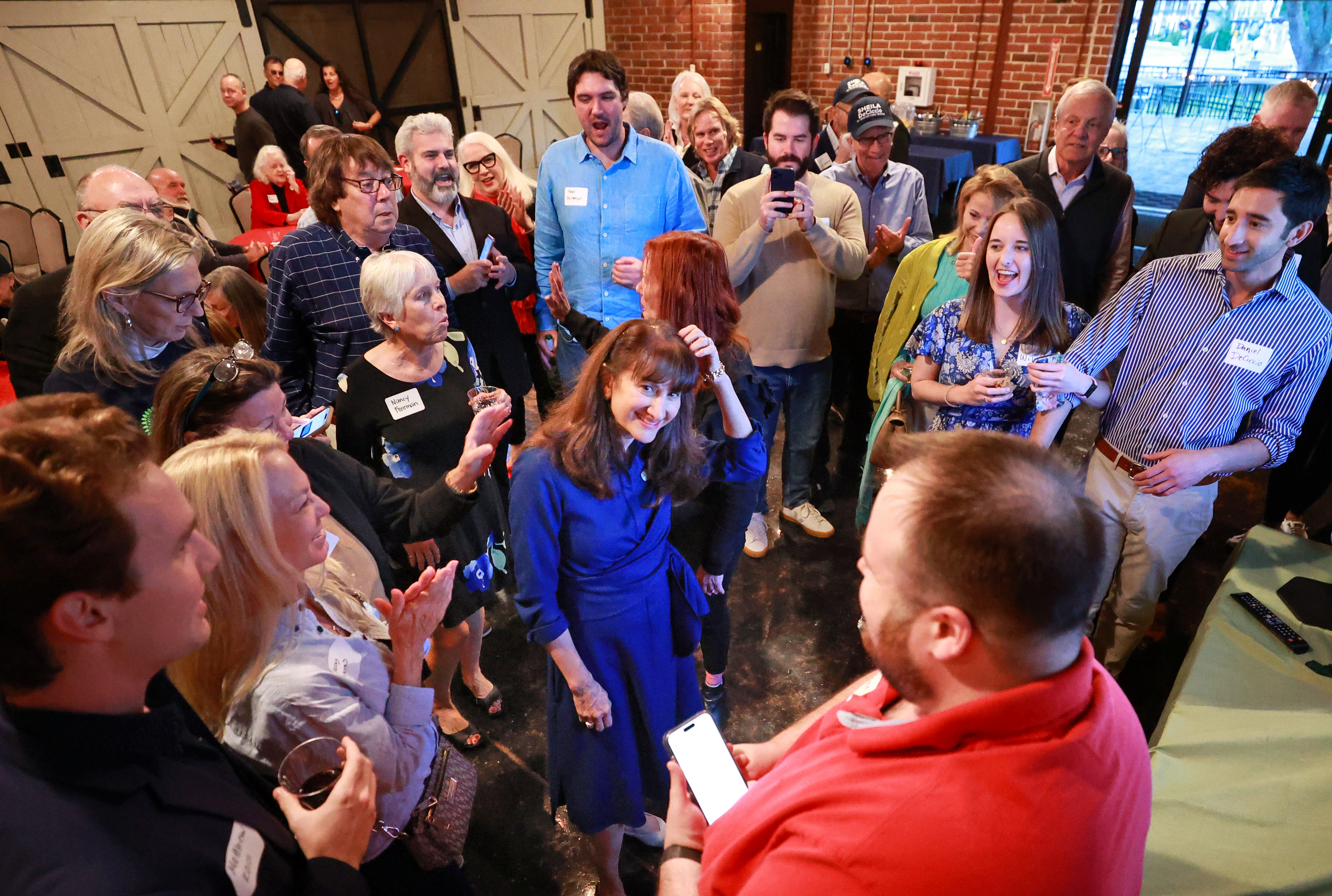 Supporters cheer as the first results come in confirming Winter Park vice mayor Sheila DeCiccio, center, has won her race to be the city's next mayor, during an election night party at the Winter Park Farmer's Market, Tuesday, March 19, 2023.  DeCiccio defeated longtime resident Michael Cameron. (Joe Burbank/Orlando Sentinel)