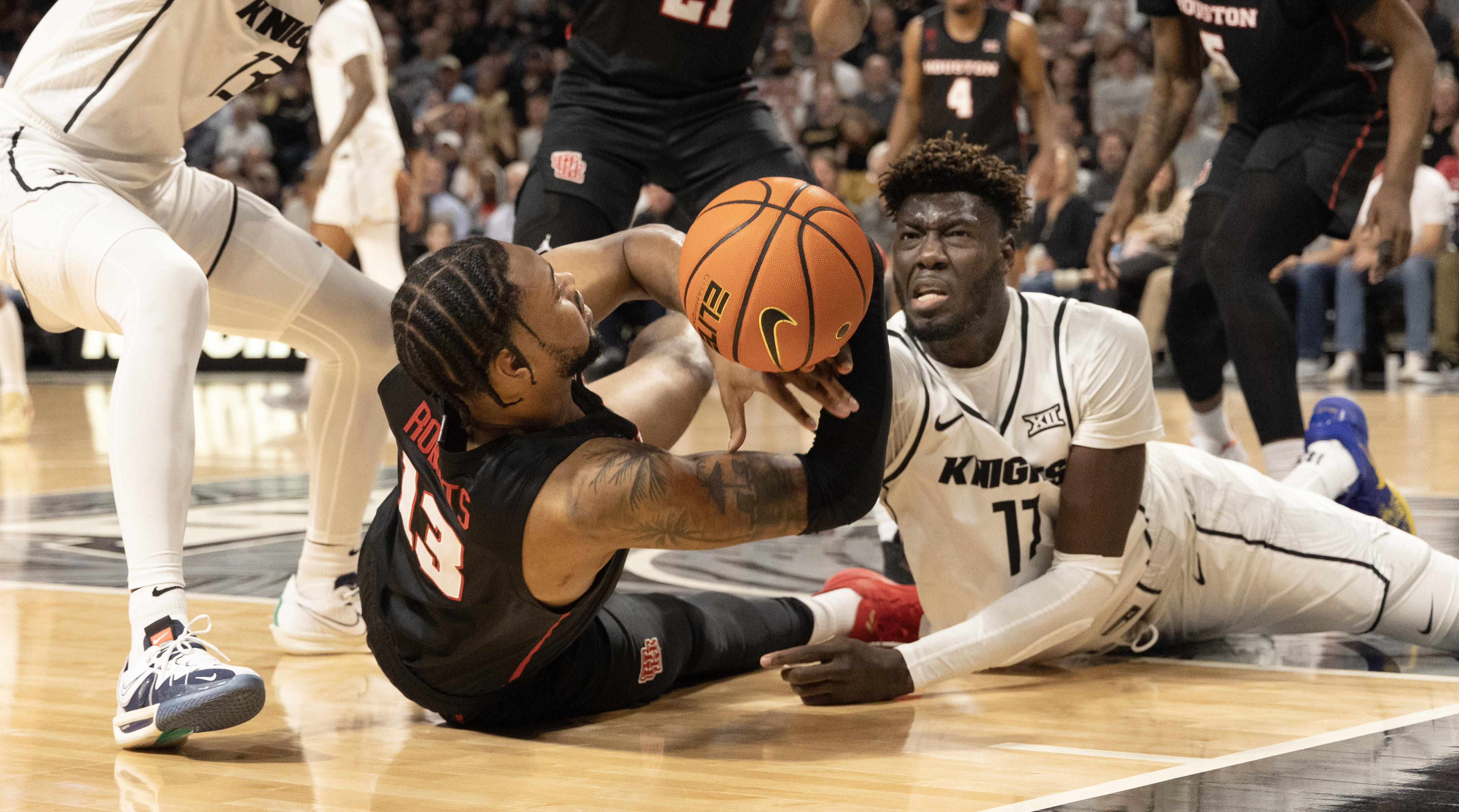 UCF Knights forward Ibrahima Diallo (11) and Houston Cougars forward J'Wan Roberts (13) fight for the ball during the UCF men's college basketball game against Houston at Addition Financial Arena in Orlando, Fla., Wednesday, March 6, 2024. (Willie J. Allen Jr./Orlando Sentinel)