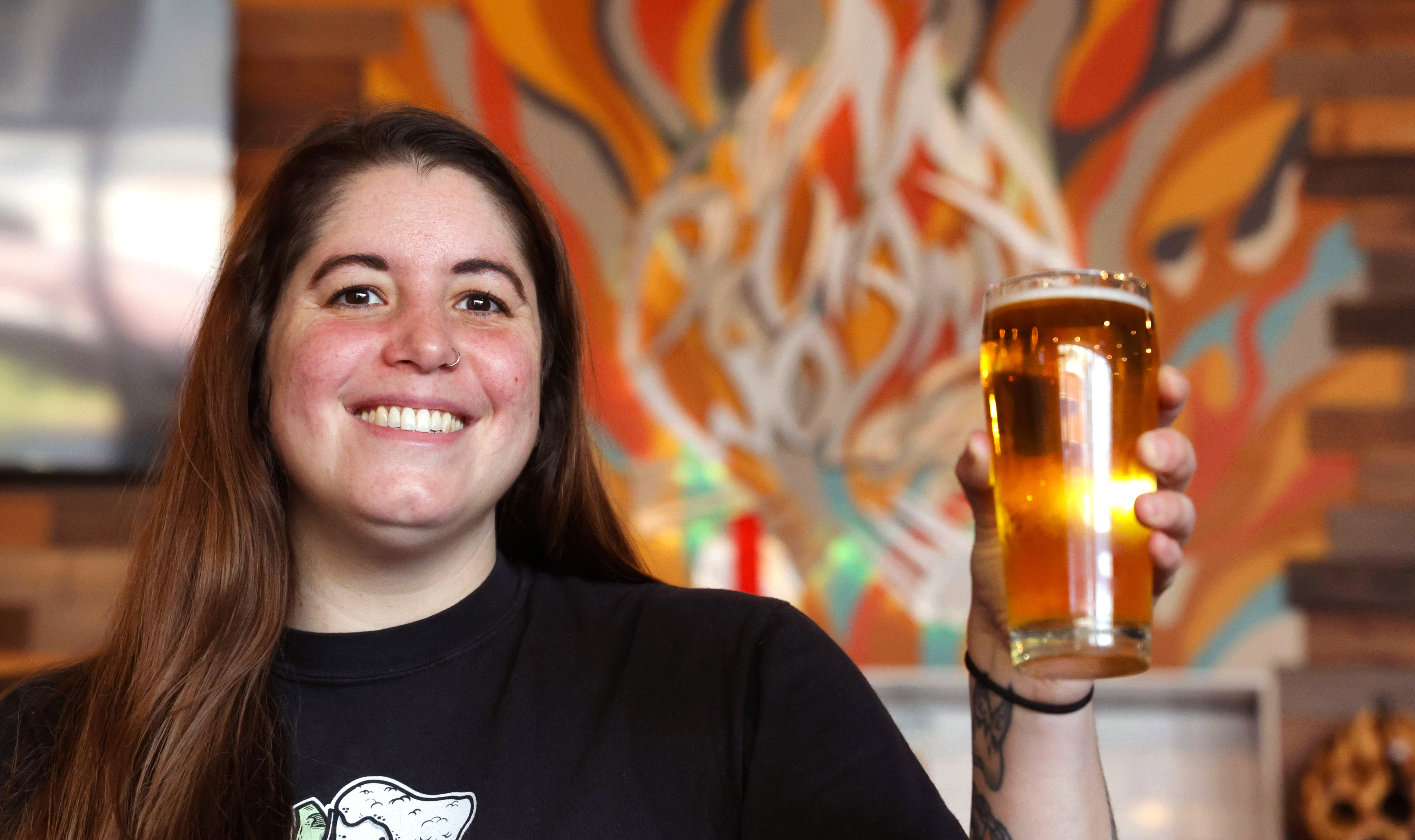 Heather Opheim of Deviant Wolfe Brewing raises a glass in downtown Sanford, Thursday, May 21, 2024. (Joe Burbank/Orlando Sentinel)