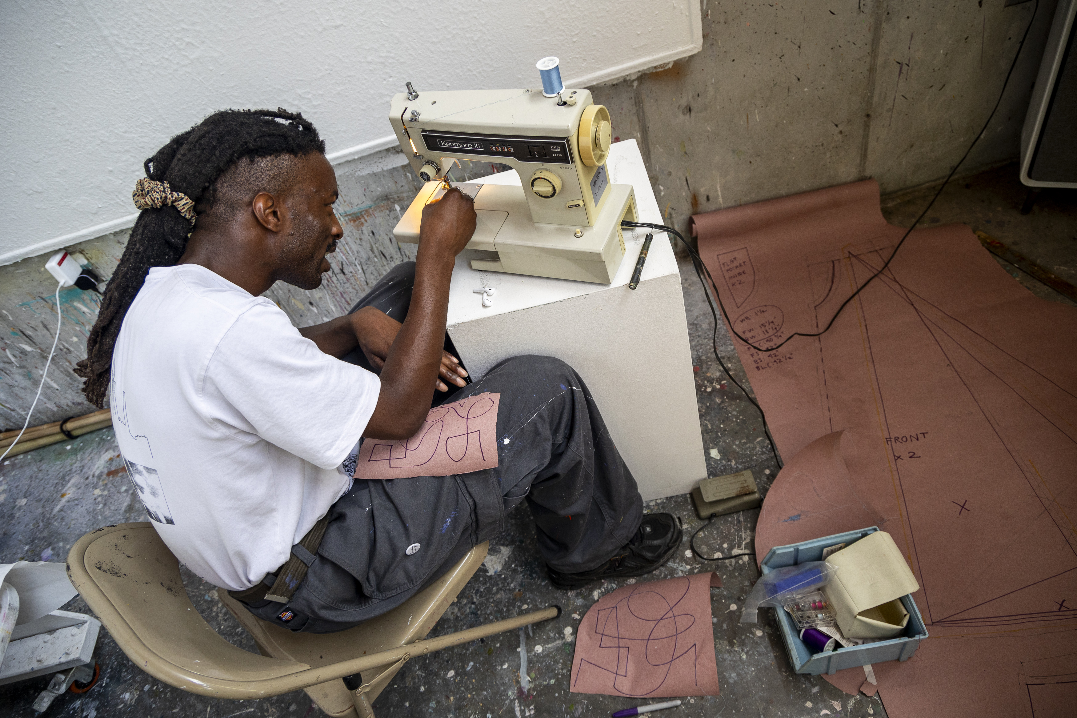 Musician and poet Adebola Oyekanmi worked on learning how to use a sewing machine at Atlantic Center for the Arts in New Smyrna Beach on July 2, 2024. (Patrick Connolly/Orlando Sentinel)