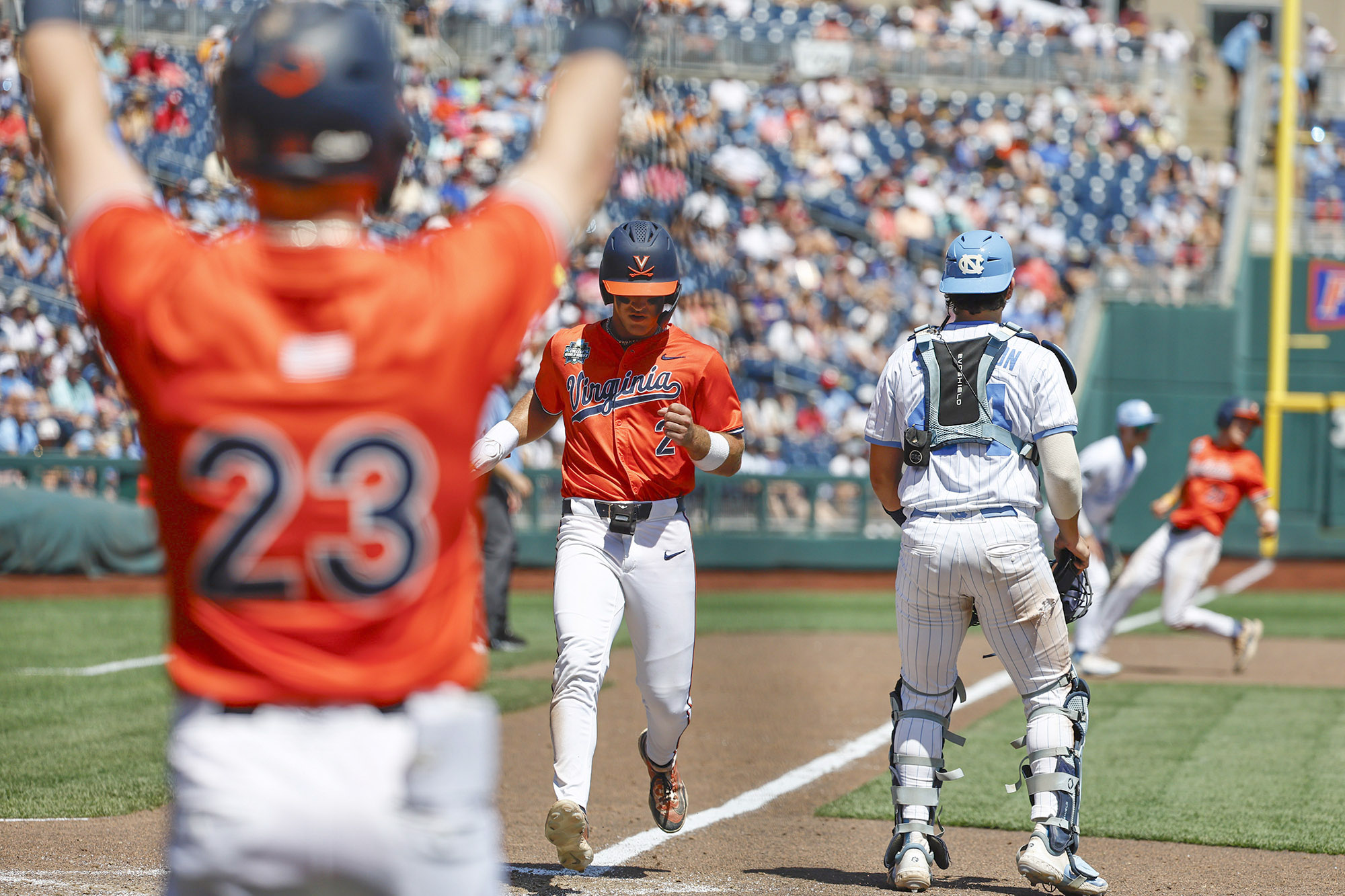 Virginia second baseman Henry Godbout scores a run on Griff O'Ferrall's sacrifice fly in the sixth inning of a College World Series game against North Carolina on Friday. (Courtesy of UVA)