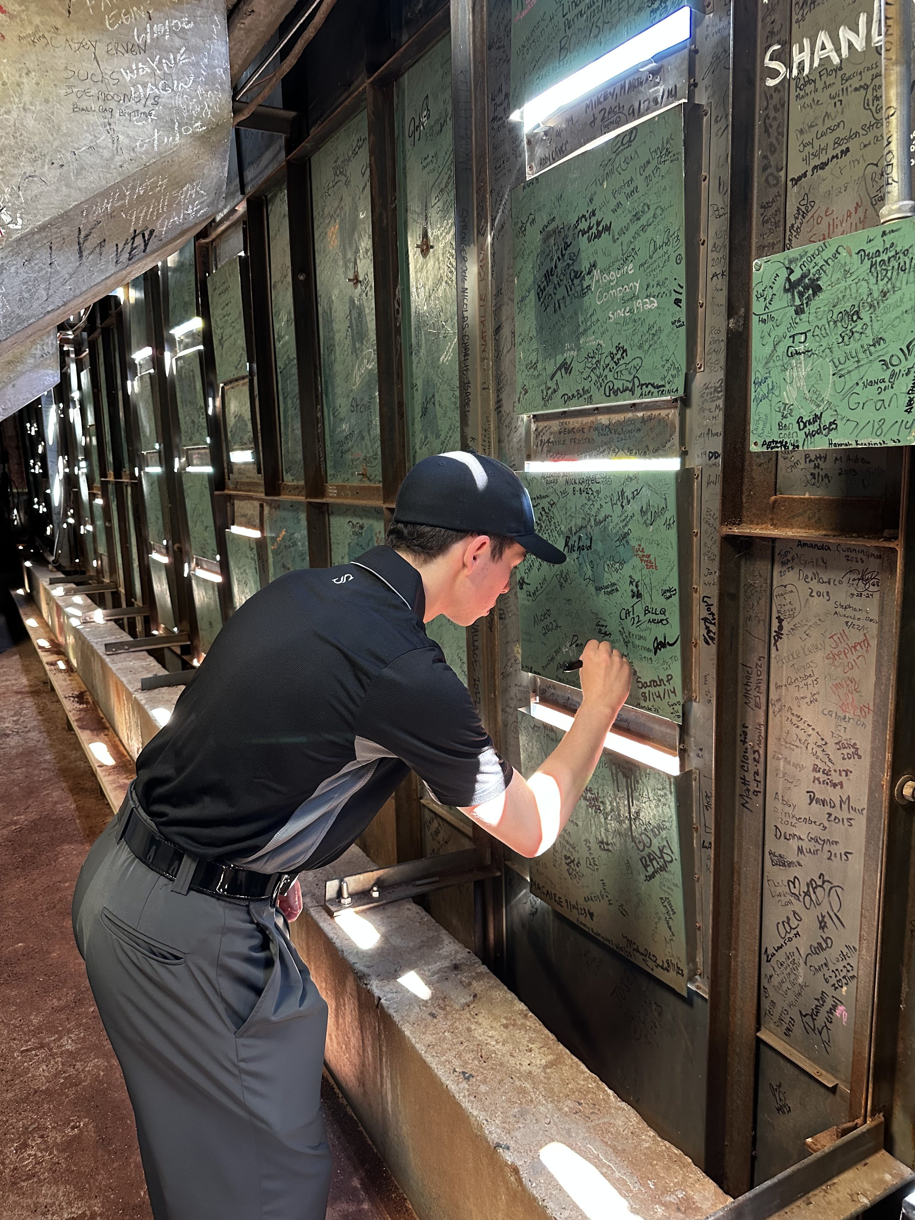 Noah Katz, shown recently signing the Green Monster at Fenway Park, has gained a foothold in the umpiring world, and increasing employment as an umpire, because of the popularity of his online "Umpire Channel."