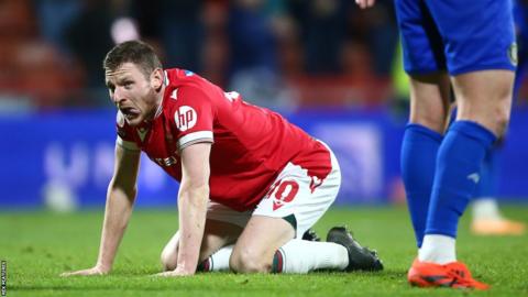 Wrexham's Paul Mullin kneels on the floor in frustration