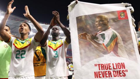 Senegal players with a banner of Papa Bouba Diop