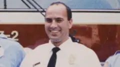 Corey Comperatore, um homem branco sorrindo com uma camisa branca e gravata preta