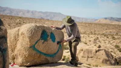 Turista rabisca pedra no deserto