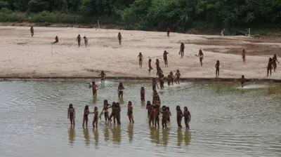 Pessoas da tribo Mashco Piro à beira de rio